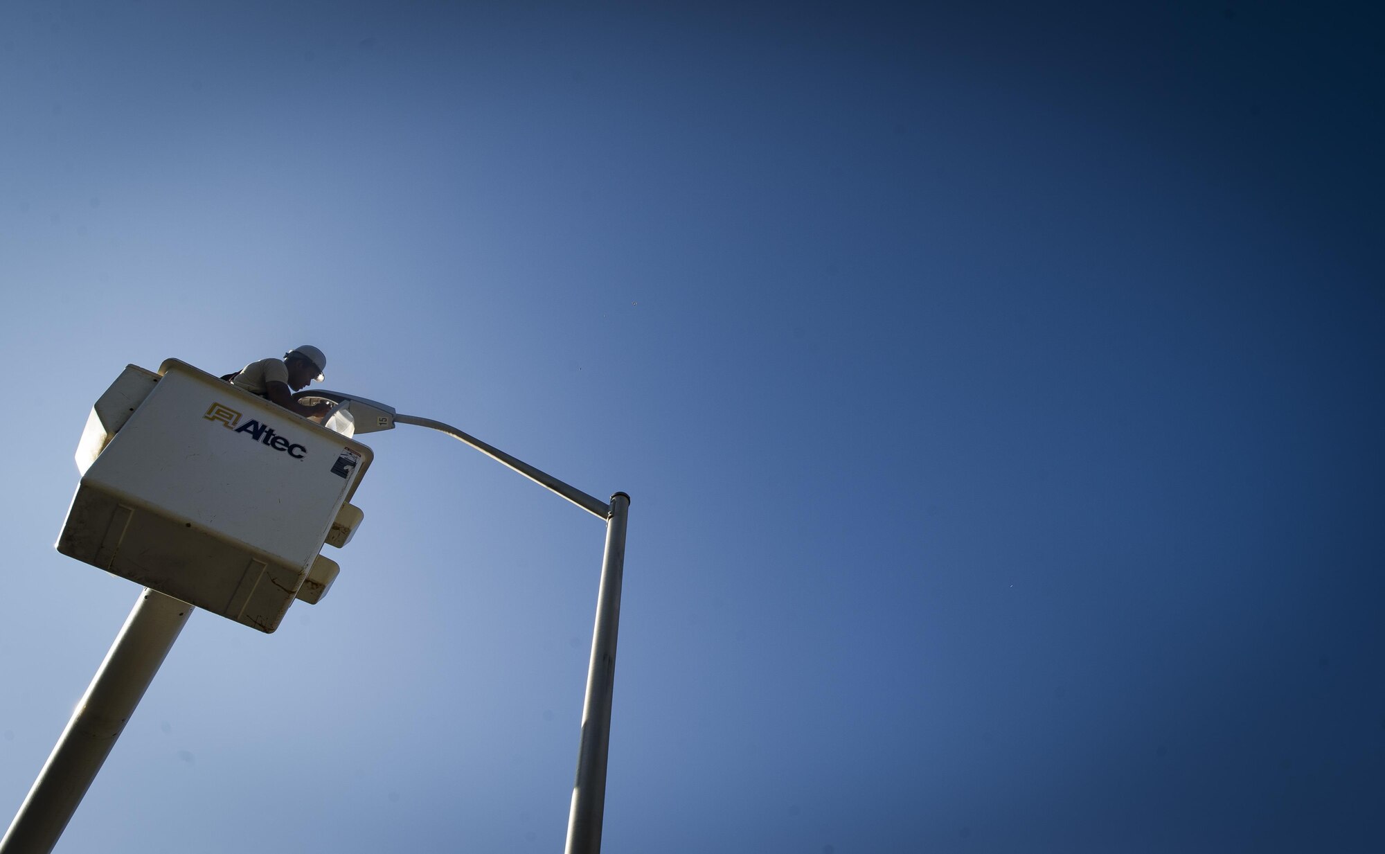 Senior Airman Darren Pizarro, 27th Special Operations Civil Engineer Squadron electrical systems specialist, replaces a faulty bulb in a light pole at Cannon Air Force Base, N.M., June 27, 2017. Specialists such as Pizarro are responsible for installing, repairing and maintaining electrical networks, ensuring that primary sources of energy are always available. From space command communicating with satellites to hospitals operating lifesaving equipment, every Air Force function depends on this crucial service provided by these experts. (U.S. Air Force photo by Senior Airman Lane T. Plummer)