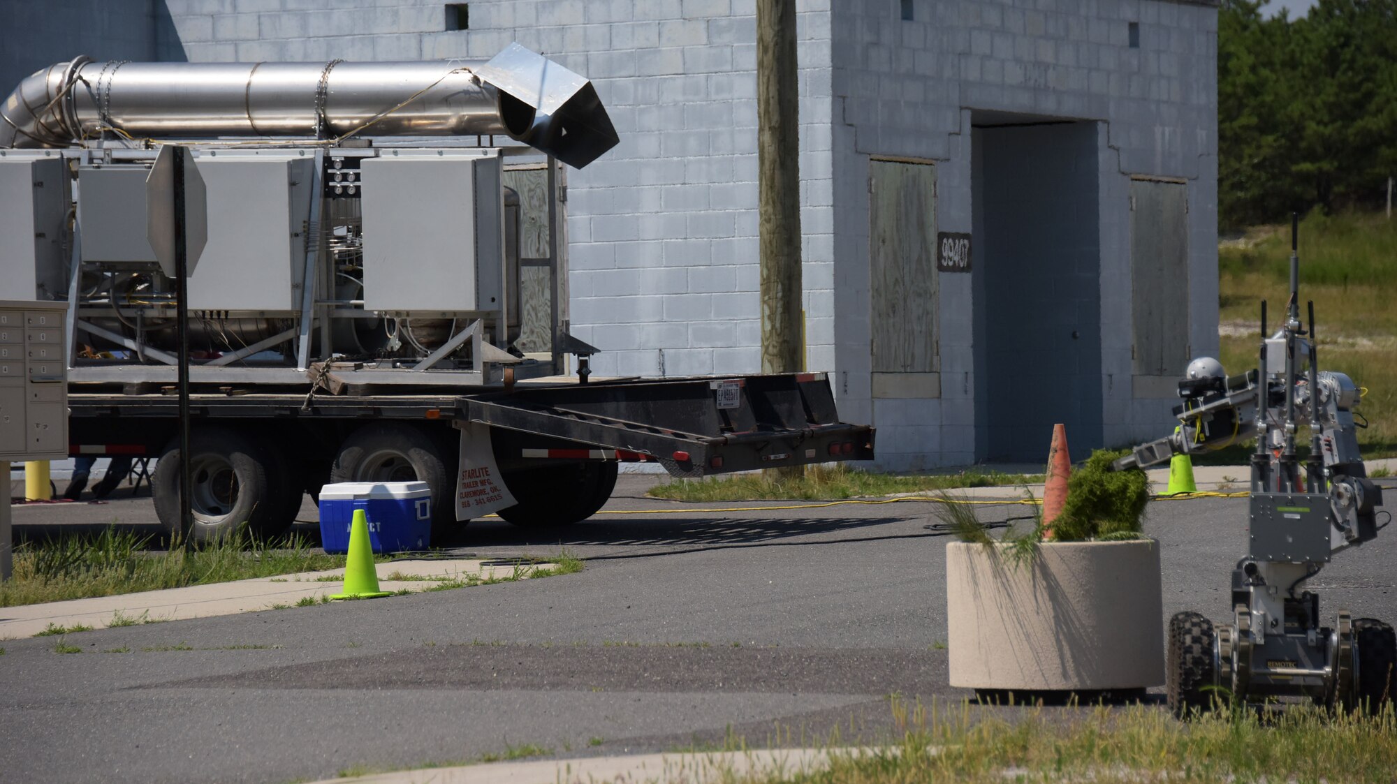An explosive ordnance disposal robot searches for a simulated dispersal unit while an Environmental Protection Agency plume generator operates in the background during a three-day, multi-agency emergency response exercise at Joint Base McGuire-Dix-Lakehurst, New Jersey, on July 12, 2017. The plume generator provided 87th Civil Engineer Squadron EOD technicians with advanced level of training by integrating larger radiation sources into training.