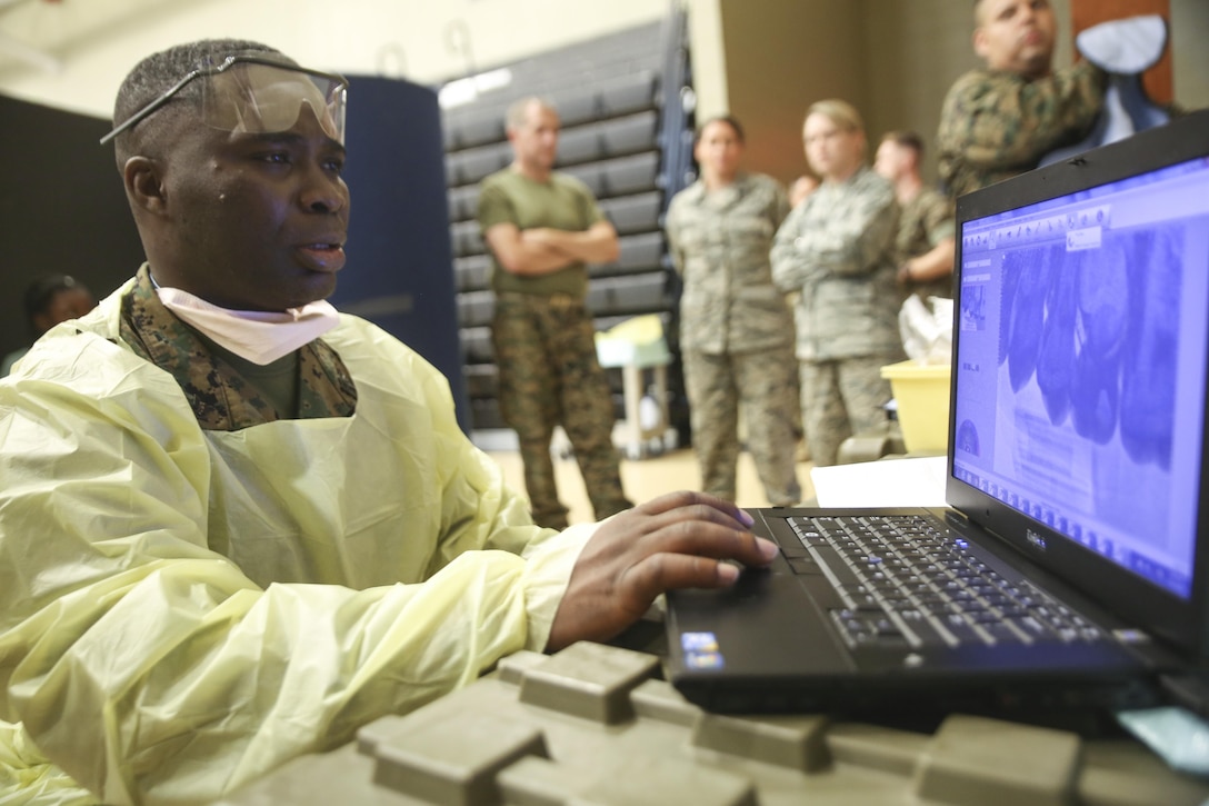 Petty Officer 3rd Class Dumbuos Asigri, a dental corpsman with 4th Dental Battalion, 4th Marine Logistics Group, Marine Forces Reserve, examines X-rays for clarity during Innovative Readiness Training Louisiana Care 2017 at Assumption Community Center in Napoleonville, La., July 12, 2017. The Louisiana Care IRT event is a joint-service medical mission that provides service members the opportunity to increase public awareness and understanding of the Marine Corps and Navy while increasing overall training and readiness. (Photo by U.S. Marine Pvt. Samantha Schwoch/Released)