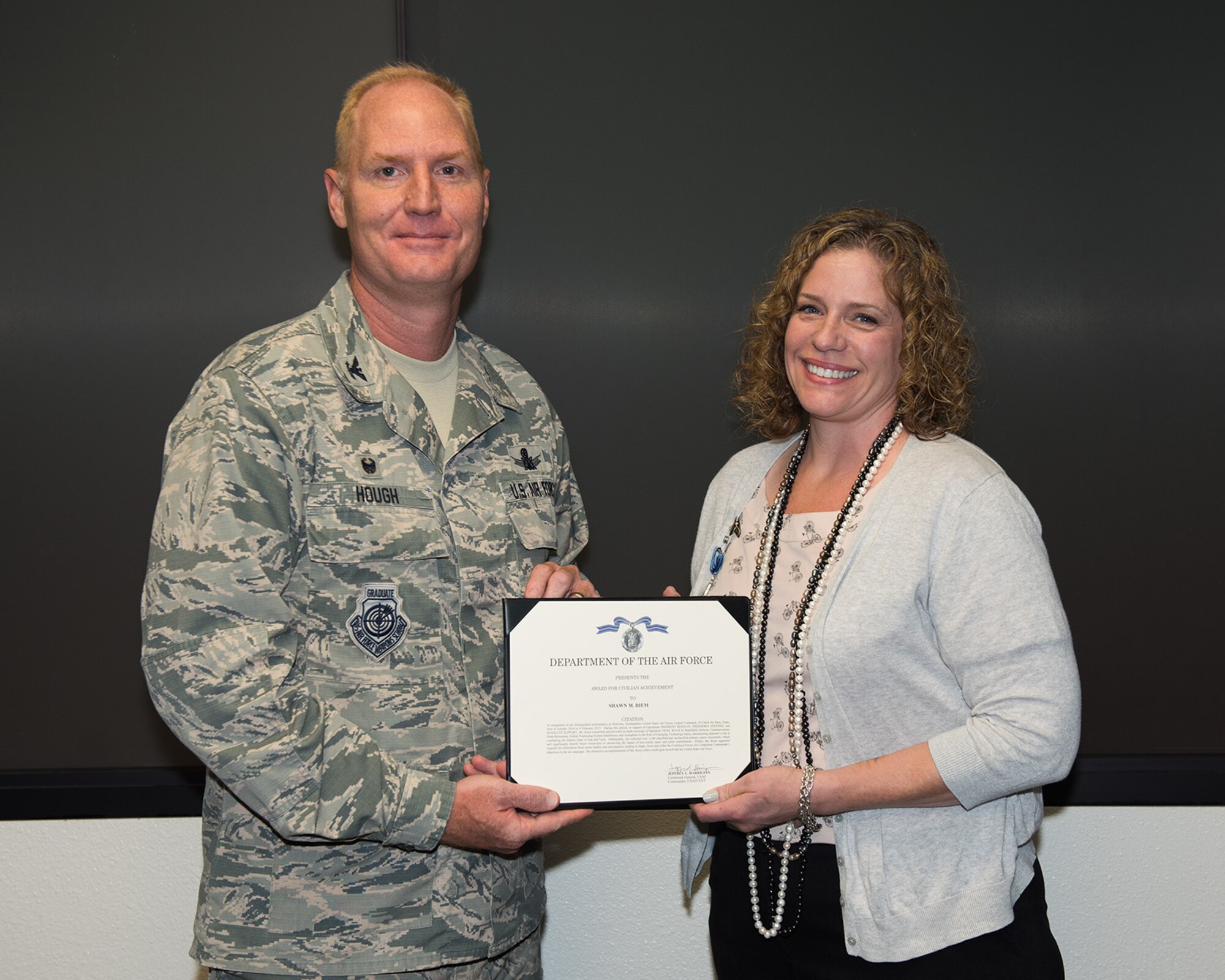 Col. Michael Hough, 30th Space Wing commander, presents Ms. Shawn Riem, 30th SW historian, with a civilian achievement award, July 12, 2017, Vandenberg Air Force Base, Calif. Riem was recognized for her distinguished performance as historian for Headquarters United States Air Forces Central Command, Al Udeid Air Base, Qatar, from Oct 2016 - Feb 2017. (U.S. Air Force photo by Michael Peterson/released)
