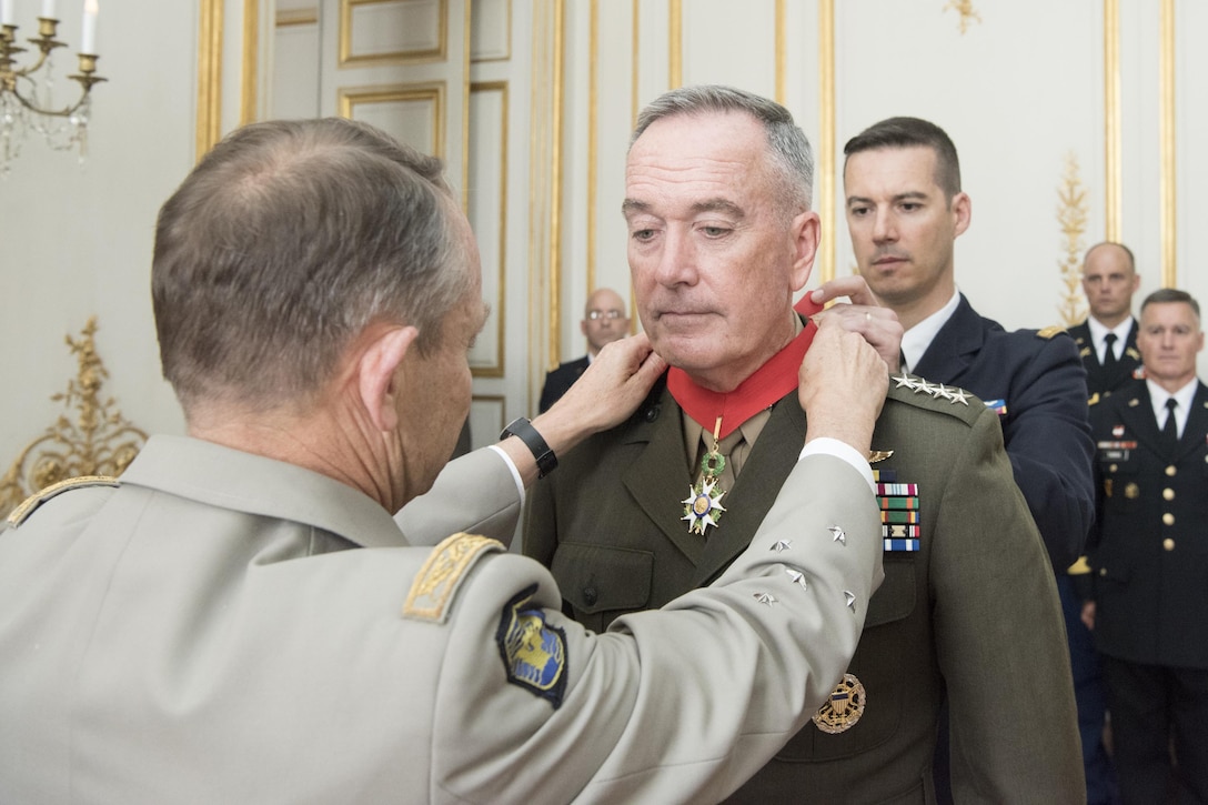 Marine Corps Gen. Joseph F. Dunford Jr., chairman of the Joint Chiefs of Staff, receives the Legion of Honor from French Gen. Pierre de Villiers, chief of the defense staff, in Paris on the eve of Bastille Day, July 13, 2017. This year, the U.S. is leading the parade as the country of honor in commemoration of the centennial of U.S. entry into World War I and the long-standing partnership between France and the U.S. DoD photo by Navy Petty Officer 2nd Class Dominique A. Pineiro