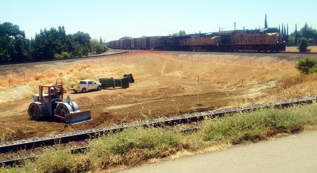 A Union Pacific train passes as the contractor works on Phase 4a of the Marysville Ring Levee project on July 7, 2017. This portion of the levee project is located in Binney Junction, adjacent to the Marysville Catholic Cemetery.