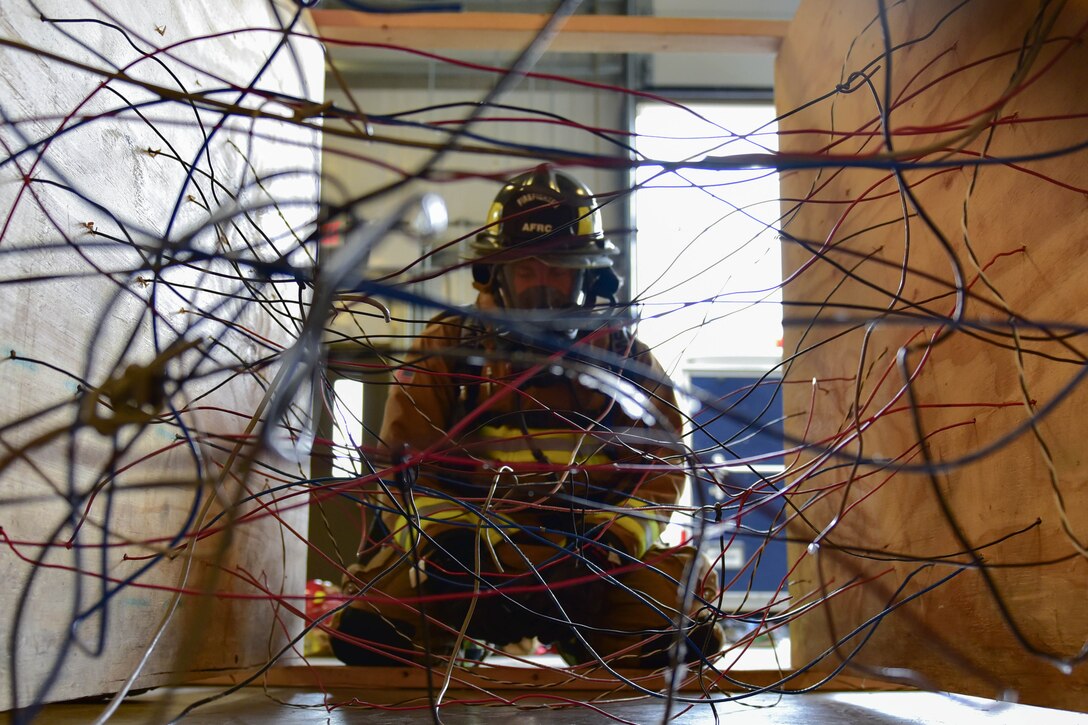 A firefighter prepares to navigate a simulated roof collapse during a training exercise, Wednesday, July 12, 2017, Niagara Falls Air Reserve Station, Niagara Falls, N.Y. The week-long training teaches participants fire ground survival techniques to be used in emergency situations. (U.S. Air Force photo by Staff Sgt. Richard Mekkri)