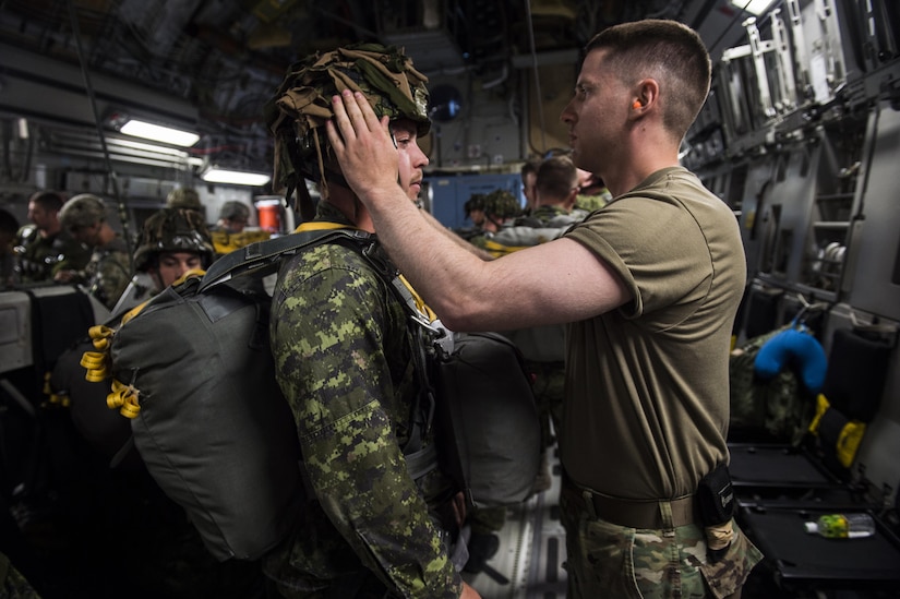 U.S. Army 1st Lt. Isaac Larue, executive officer, Alpha Company, 4th Brigade 25th Infantry division, checks the gear of a paratrooper from Princess Patricia's Canadian Light Infantry while onboard a U.S. Air Force C-17 Globemaster III from Joint Base Charleston, S.C., July 12, 2017 to conduct an air drop to participate in Exercise Talisman Saber 2017. The purpose of TS17 is to improve U.S.-Australian combat readiness, increase interoperability, maximize combined training opportunities and conduct maritime prepositioning and logistics operations in the Pacific. TS17 also demonstrates U.S. commitment to its key ally and the overarching security framework in the Indo Asian Pacific region.