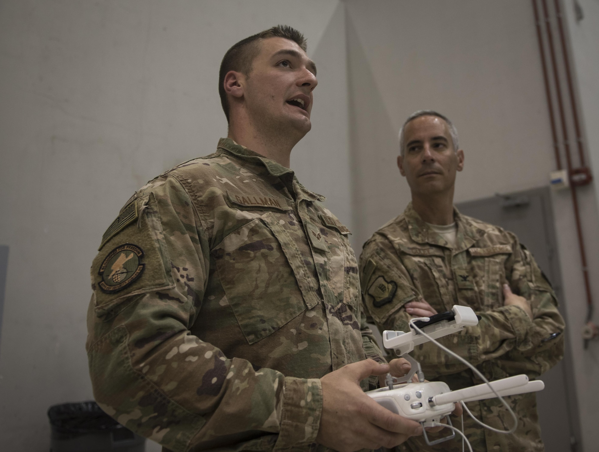 Senior Airman Christopher Gallman, 455th Expeditionary Security Forces Squadron joint defense operations center, speaks to Col. Bradford Coley, the 455th Expeditionary Mission Support Group commander, about the unmanned aircraft systems program during a live-demonstration at Bagram Airfield, Afghanistan, June 30, 2017. The 455th ESFS teamed up with a researcher from the Air Force Research Lab to teach Airmen how to pilot drones and use them to train coalition partners on how to react to them on the battlefield. (U.S. Air Force photo by Staff Sgt. Benjamin Gonsier) 