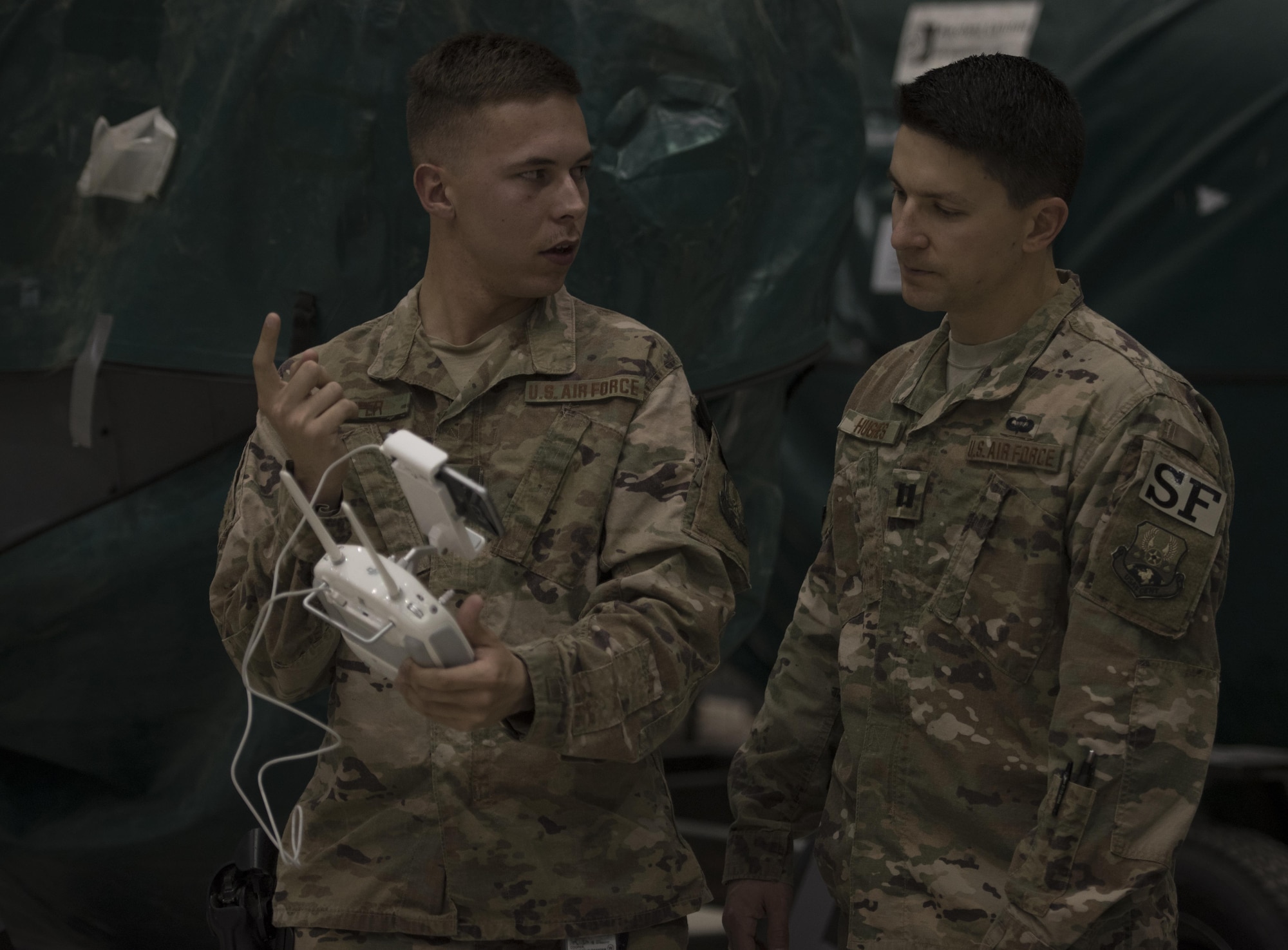Airman 1st Class Brandon Cooper, 455th Expeditionary Security Forces Squadron, explains the unmanned aircraft systems program to then-Capt. Tyler Hughes, the 455th ESFS commander, during a live-demonstration at Bagram Airfield, Afghanistan, June 30, 2017. The 455th ESFS teamed up with a researcher from the Air Force Research Lab to teach Airmen how to pilot drones and use them to train coalition partners on how to react to them on the battlefield. (U.S. Air Force photo by Staff Sgt. Benjamin Gonsier) 