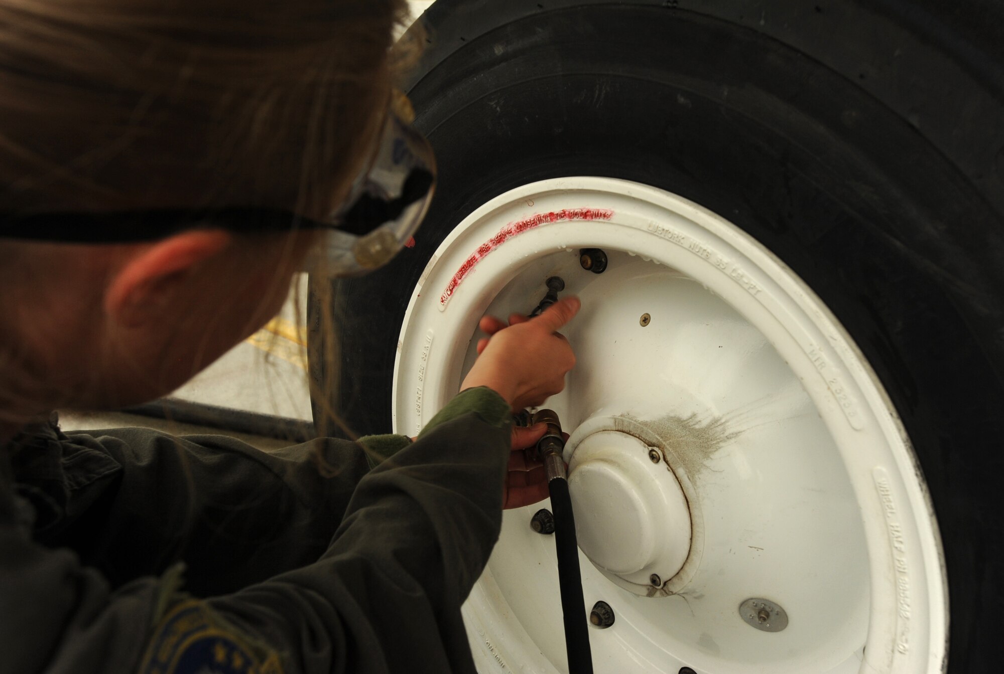 Senior Airman Kailey Simmonds, 22nd Aircraft Maintenance Squadron assistant flying crew chief, attaches a hose to the valve stem on a KC-135 Stratotanker tire, July 11, 2017, at Eielson Air Force Base, Ala. The other side of the hose is attached to a nitrogen servicing cart which supplies the nitrogen to fill the tires to the correct PSI. (U.S. Air Force photo/Staff Sgt. Rachel Waller)