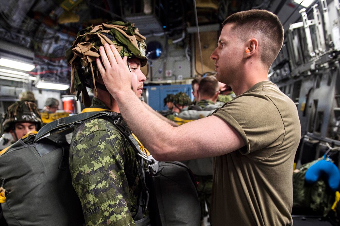 Army 1st Lt. Isaac Larue, right, checks the gear of Canadian paratroopers aboard a C-17 Globemaster III, July 12, 2017, before conducting airborne operations in Exercise Talisman Saber 2017. Larue is an executive officer assigned to the 25th Infantry Division’s Company A, 4th Brigade. Air Force photo by Tech. Sgt. Gregory Brook