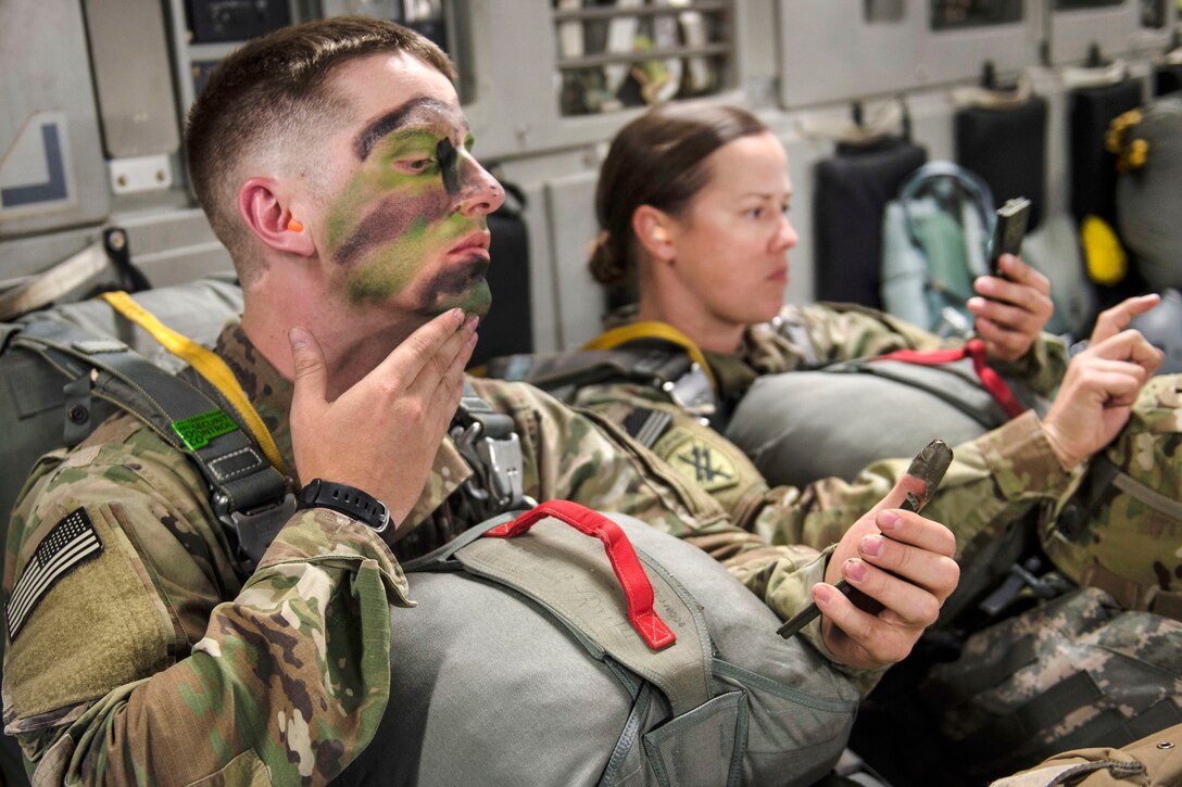 U.S. and Canadian paratroopers apply face paint aboard a C-17 Globemaster III, July 12, 2017, before conducting airborne operations in Exercise Talisman Saber 2017. Air Force photo by Tech. Sgt. Gregory Brook