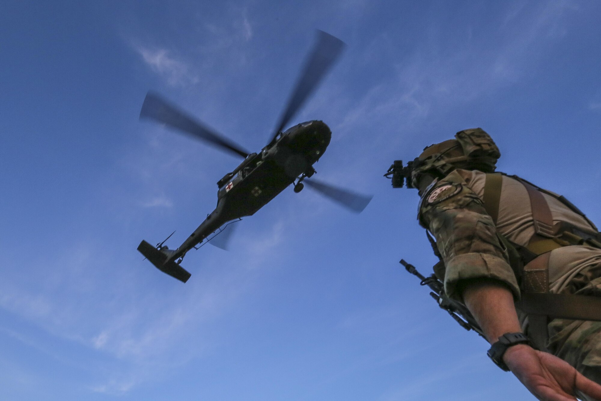 Senior Airman Sean Meehan, a tactical air control party Airman from the 227th Air Support Operations Squadron assigned to New Jersey Task Force One, looks up at a hovering Army National Guard UH-60 Black Hawk helicopter during joint training at Joint Base McGuire-Dix-Lakehurst, N.J., June 28, 2017. The primary mission of New Jersey Task Force One is to provide advanced technical search and rescue capabilities to victims trapped or entombed in structurally collapsed buildings. (U.S. Air National Guard photo/Master Sgt. Matt Hecht)