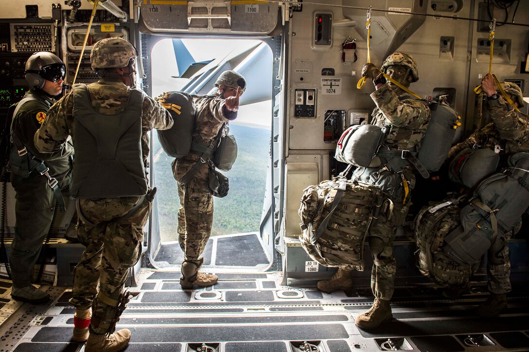 An Army jumpmaster gives the "one minute" signal to U.S. and Canadian paratroopers from the door of a C-17 Globemaster III, July 12, 2017. Air Force photo by Tech. Sgt. Gregory Brook 