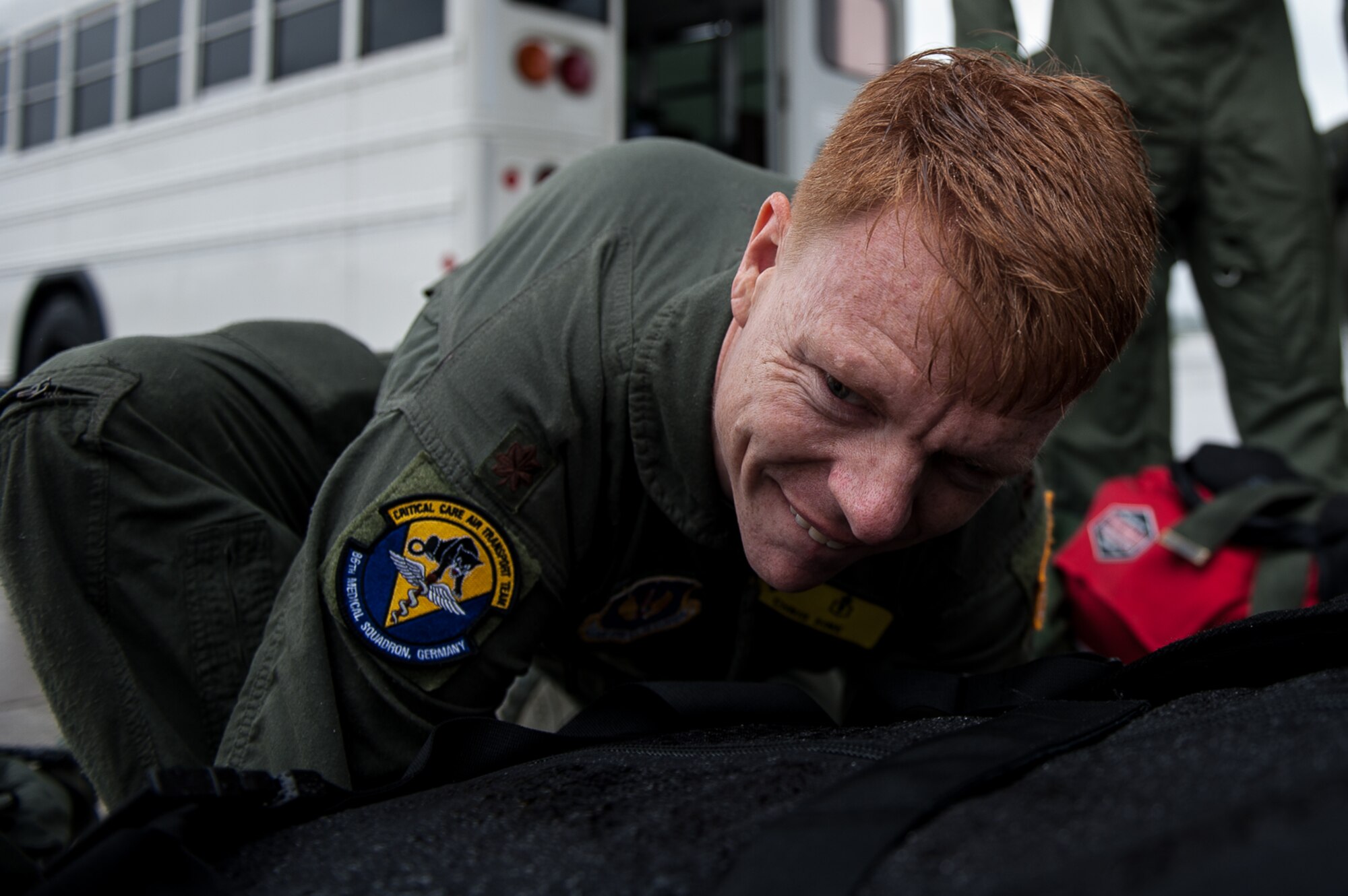 U.S. Air Force Maj. Chris Sine, 86th Medical Squadron Critical Care Air Transportation Team member, straps medical gear to a litter during a training exercise on the flightline on Ramstein Air Base, Germany, July 12, 2017. The CCATT carries approximately 650 lbs of medical gear with them on every mission they go on. (U.S. Air Force photo by Senior Airman Devin Boyer)