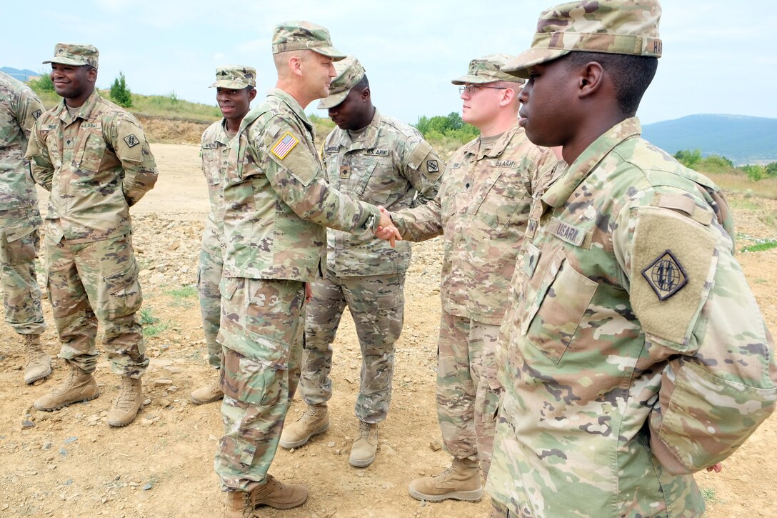 Command Sgt. Maj. Raymond Brown, senior enlisted leader of the 7th Mission Support Command, presents coins, July 13, 2017 to the Soldiers of 2nd Platoon, Charlie Co., 44th Expeditionary Signal Battalion, from Grafenwoehr, Germany, for their efforts in keeping communications going for the 21st Theater Sustainment Command's Forward Command Post during Exercise Saber Guardian 17 at Novo Selo Training Area in Bulgaria. 