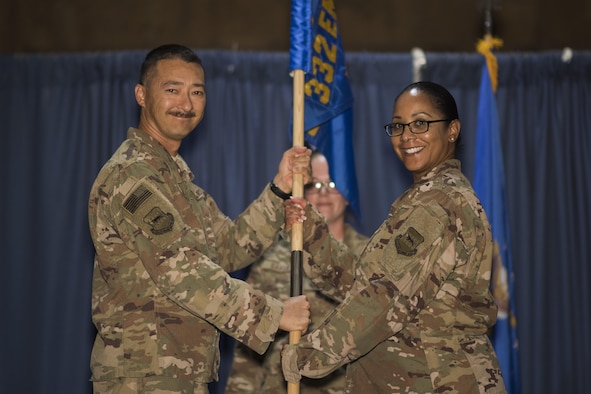Col. Christopher K. Fuller, 332nd Expeditionary Mission Support Group commander, left, passes the guidon to Maj. Lydia A. Bradley-Tyler, during the 332nd Expeditionary Force Support Squadron assumption of command ceremony July 13, 2017, in Southwest Asia. The passing of a guidon symbolizes a unit’s transfer of command. (U.S. Air Force photo/Senior Airman Damon Kasberg)