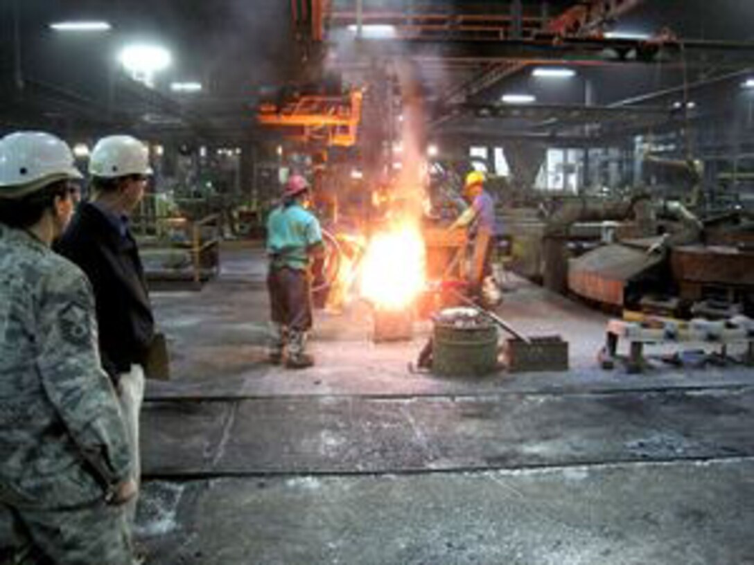 DLA Aviation’s Air Force Master Sgt. Gabriela Camarillo, left, watches casting at the Buck Company foundry, Quarryville, Pennsylvania.