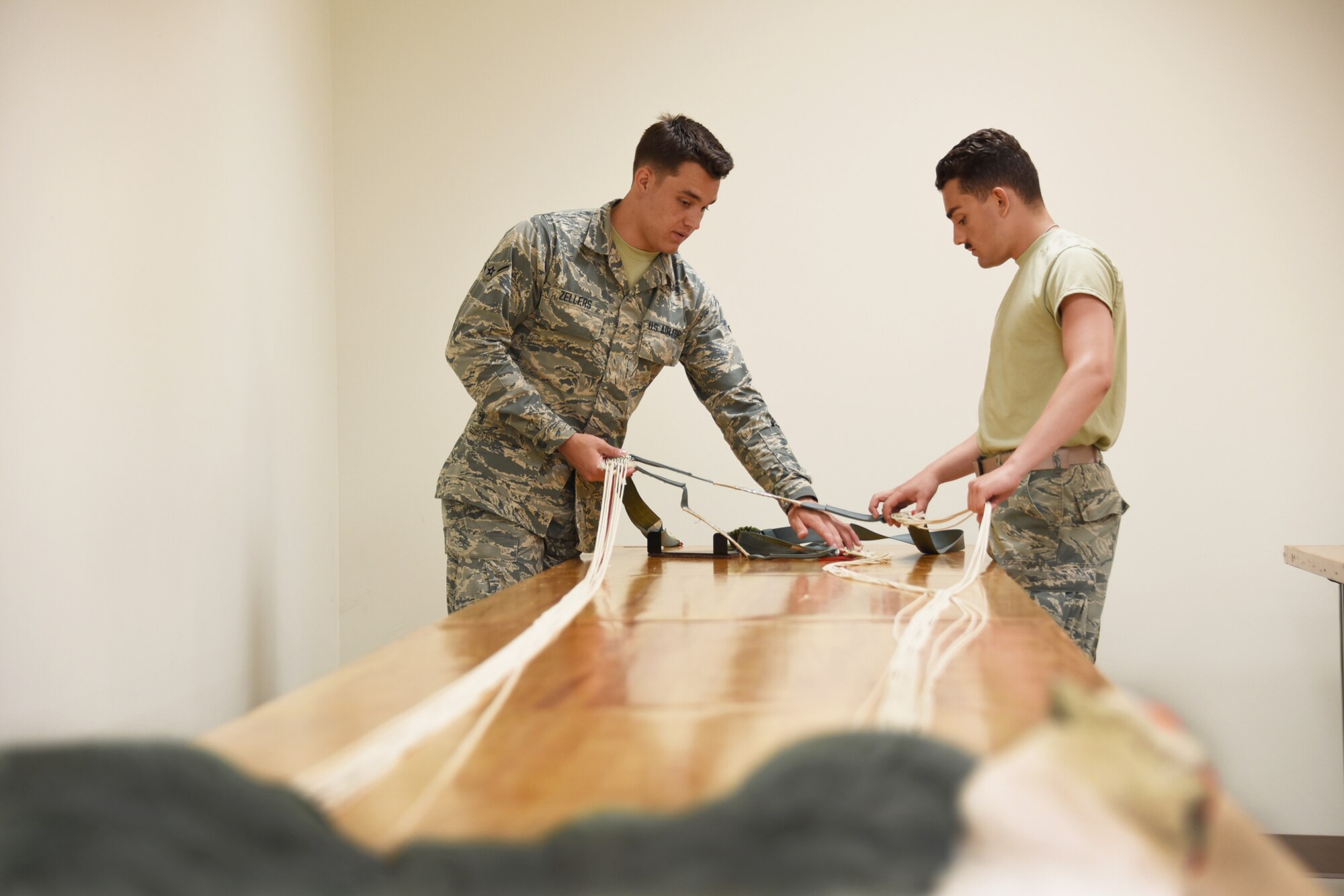 Airmen Bryant Zellers and Anton Trenga, 361st Training Squadron aircrew flight equipment apprentice students ensure that all flight and safety equipment is in perfect working order at Sheppard Air Force Base, Texas. In this course students learn to recover, assemble, inspect and pack the ACES II Recovery parachute. This parachute system is stowed behind the crewman’s seat headrest and is projected after the ejection seat is projected from the F-16 aircraft. (U.S. Air Force photo/Liz H. Colunga)