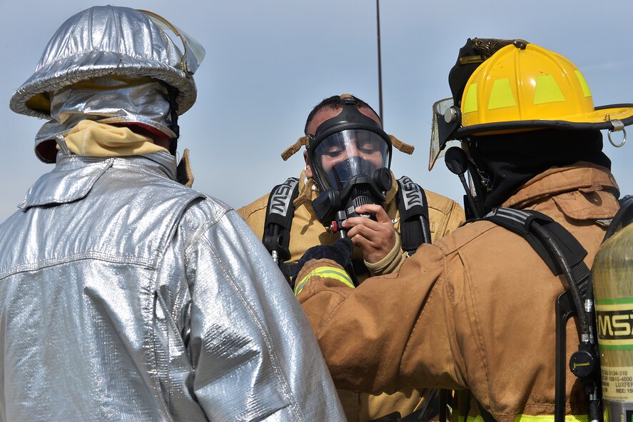 Staff Sgt. Ayo Deleimokhome, with the 139th Airlift Wing Fire and Emergency Services from St. Joseph, Missouri gets his oxygen mask tested by Tech. Sgt. Kyle Clark, Offutt Air Force Base Nebraska Fire and Rescue, after participating in a simulated aircraft fire on Offutt AFB, Nebraska, June 6. The exercise allows firefighters to safely improve search and rescue capabilities and fire response skills. (U.S. Air Force photo by Charles Haymond)