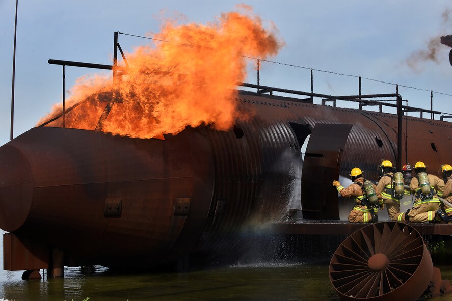 Firefighters from both Offutt Air Force Base, Nebraska and 139th Airlift Wing Fire and Emergency Services from St. Joseph, Missouri participate in a training exercise of a simulated aircraft fire on Offutt AFB, Nebraska, June 6. The exercise provided first-hand experience what tools and techniques are needed to perform the duties of a firefighter on various Air Force bases. (U.S. Air Force photo by Charles Haymond)