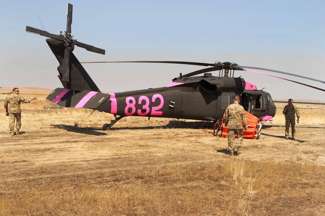 California Army National Guard pilots and crew chiefs head to a UH-60 Black Hawk helicopter at Coalinga Municipal Airport, California, July 13, 2017, to join firefighting efforts during the Garza Fire in Kings County. Army National Guard photo by Staff Sgt. Eddie Siguenza