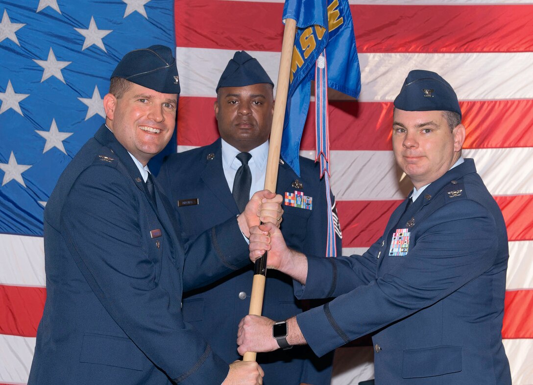 Col. Yancey Cowen, right, accepts the 71st Mission Support Group guidon from Col. Fred Cunningham, 71st Flying Training Wing vice commander, during a change-of-command ceremony held June 29 at Vance Air Force Base, Oklahoma. In background is Master Sgt. Willie Mitchell, the 71st MSG first sergeant. (U.S. Air Force photo/ Terry Wasson)