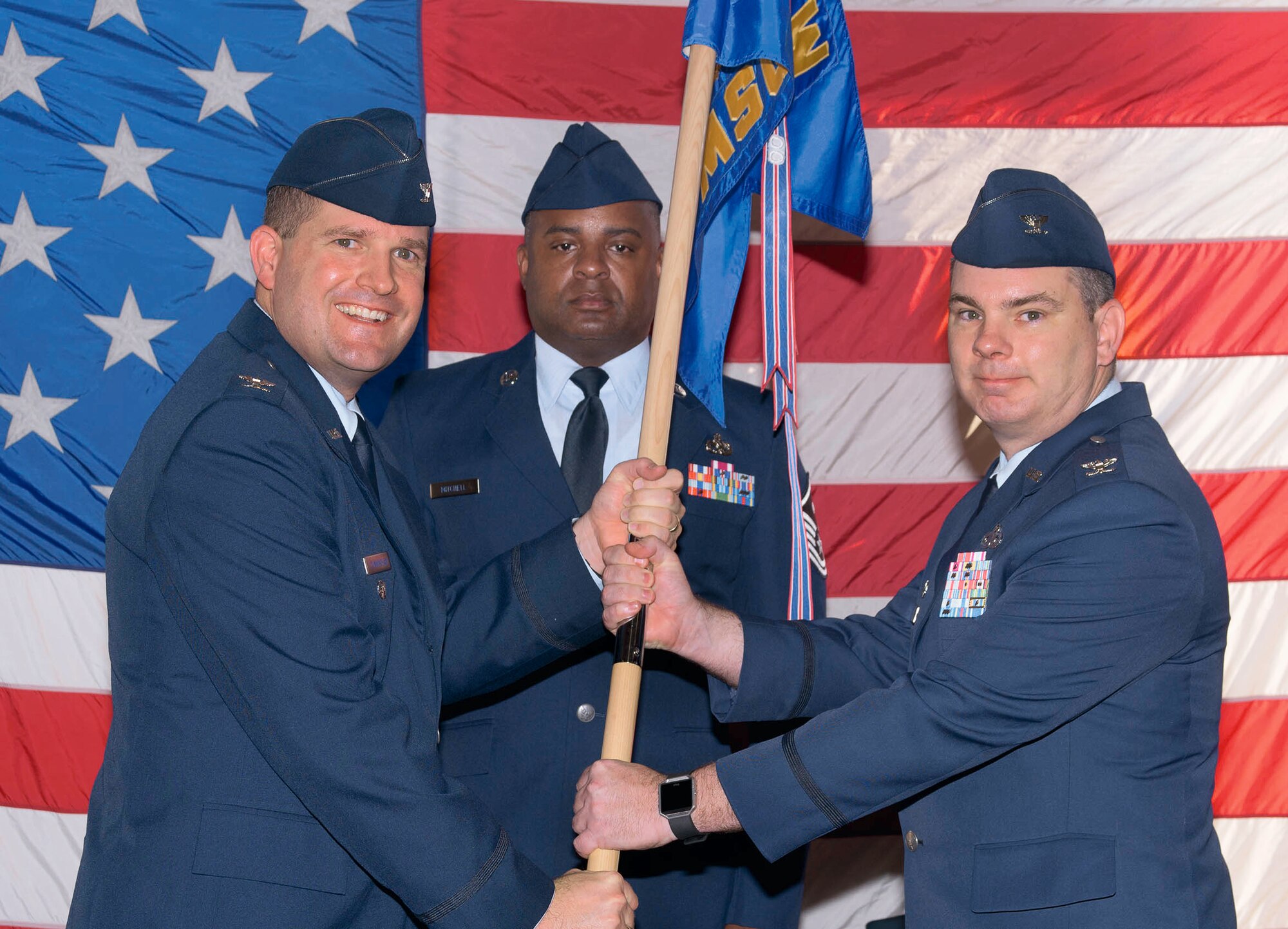 Col. Yancey Cowen, right, accepts the 71st Mission Support Group guidon from Col. Fred Cunningham, 71st Flying Training Wing vice commander, during a change-of-command ceremony held June 29 at Vance Air Force Base, Oklahoma. In background is Master Sgt. Willie Mitchell, the 71st MSG first sergeant. (U.S. Air Force photo/ Terry Wasson)