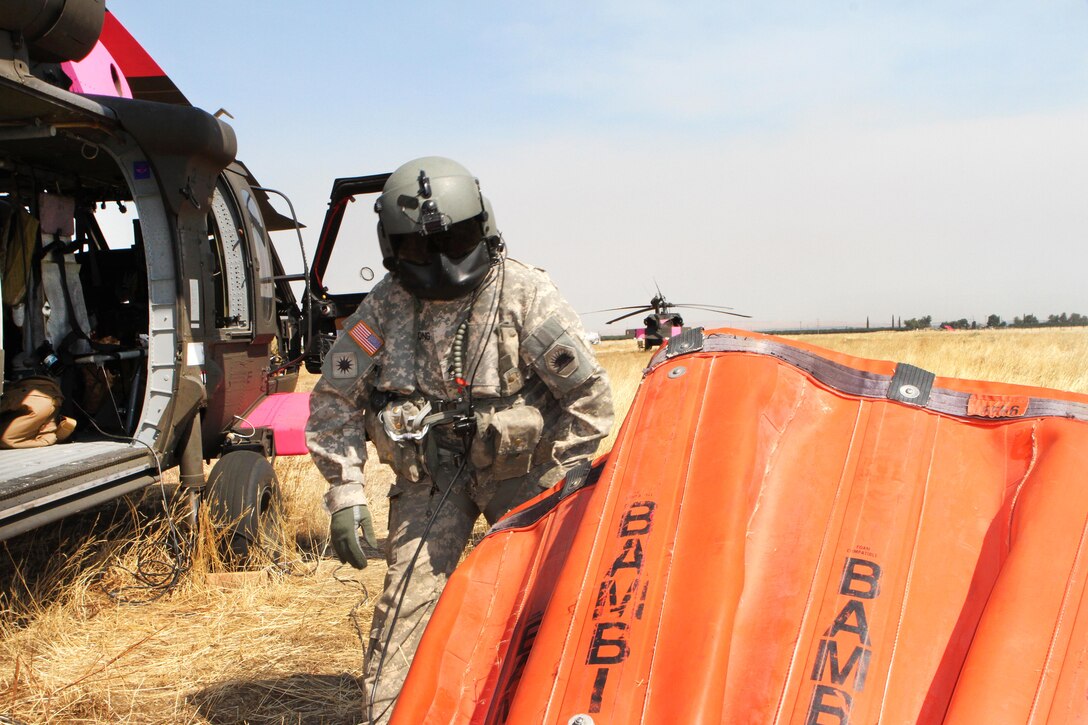 California Army National Guard Staff Sgt. Ge Xiong prepares a 2,600-gallon bucket firefighting system at Coalinga Municipal Airport, California, July 13, 2017, before supporting firefighting efforts during the Garza Fire in Kings County. Army National Guard photo by Staff Sgt. Eddie Siguenza
