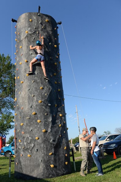 Airmen and family members climb a rock wall on July 8, 2017 at Offutt’s base lake during the annual fireworks display. The annual event included games, refreshments and a fireworks display at dusk. (U.S. Air Force photo by Zachary Hada)

