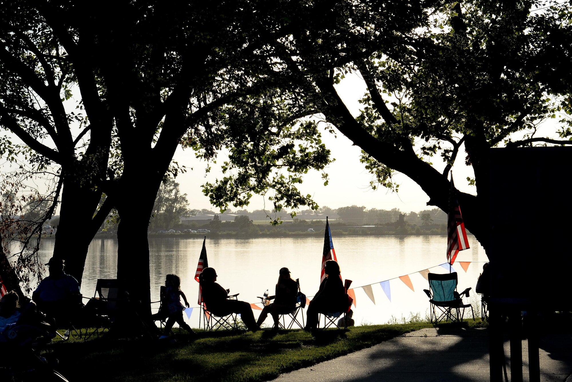 Members of the Offutt community relax at the base lake on July 8, 2017 during the annual fireworks display. The annual event included games, refreshments and a fireworks display at dusk. (U.S. Air Force photo by Zachary Hada)