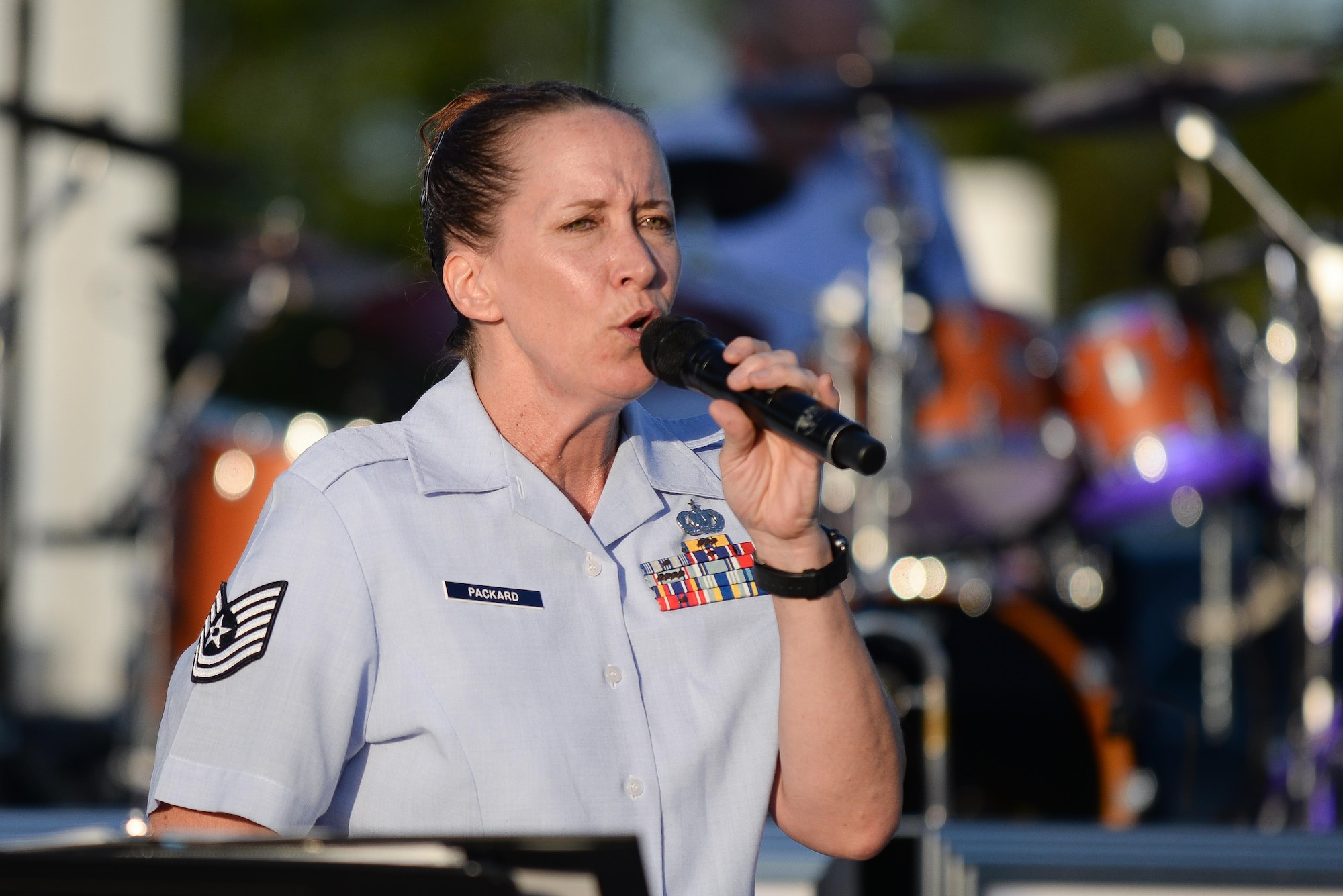 Tech. Sgt. Rebecca Packard, a vocalist with the U.S. Heartland of America Band, sings at Offutt’s base lake on July 8, 2017 during the annual fireworks display. The annual event included games, refreshments and a fireworks display at dusk. (U.S. Air Force photo by Zachary 