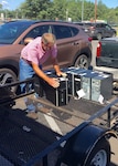 Tommy Gentry loads one-time military computers on to a trailer that his school district acquired through DLA Disposition Services' Computers for Learning program