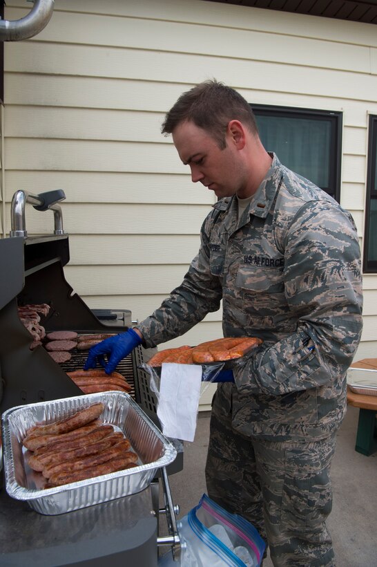 Second Lt. Seth Snyder, 90th Missile Wing chaplain candidate, grills burgers and brats during the 319th Missile Squadron code change burger burn in the 90th Missile Wing missile complex, July 12, 2017. The burger burn allows 319th MS leadership to demonstrate their sincere appreciation for the Airmen by thanking them for their hard work with a hearty meal. (U.S. Air Force photo by Staff Sgt. Christopher Ruano)