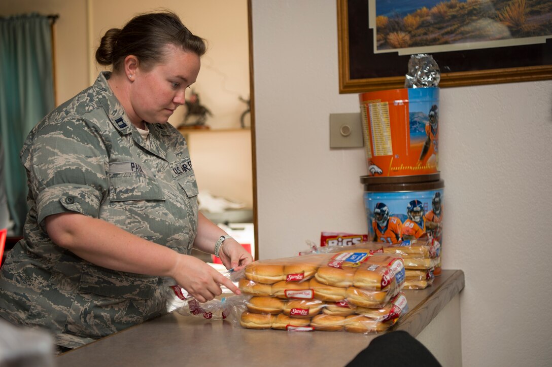 Captain Morgan Pack, 319th Missile Squadron flight commander, prepares plates and buns during the 319th MS code change burger burn in the 90th Missile Wing missile complex, July 12, 2017. Leadership from the 319th MS, along with the assistance of 90th MW chaplains, traversed the missile complex during the squadron’s week-long code change, providing food and talking to the Airmen tackling their critical mission. (U.S. Air Force photo by Staff Sgt. Christopher Ruano)