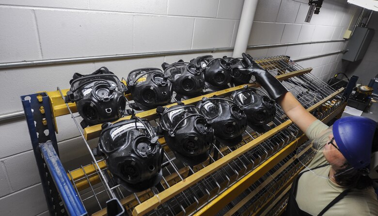 Senior Airman Jordan Parker, a materiel management journeyman with the 1st Special Operations Logistics Readiness Squadron, sets a gas mask on a drying rack at Hurlburt Field, Fla., July 10. 2017. Gas masks dry overnight before being tested for serviceability. (U.S. Air Force photo by Airman 1st Class Isaac O. Guest IV)