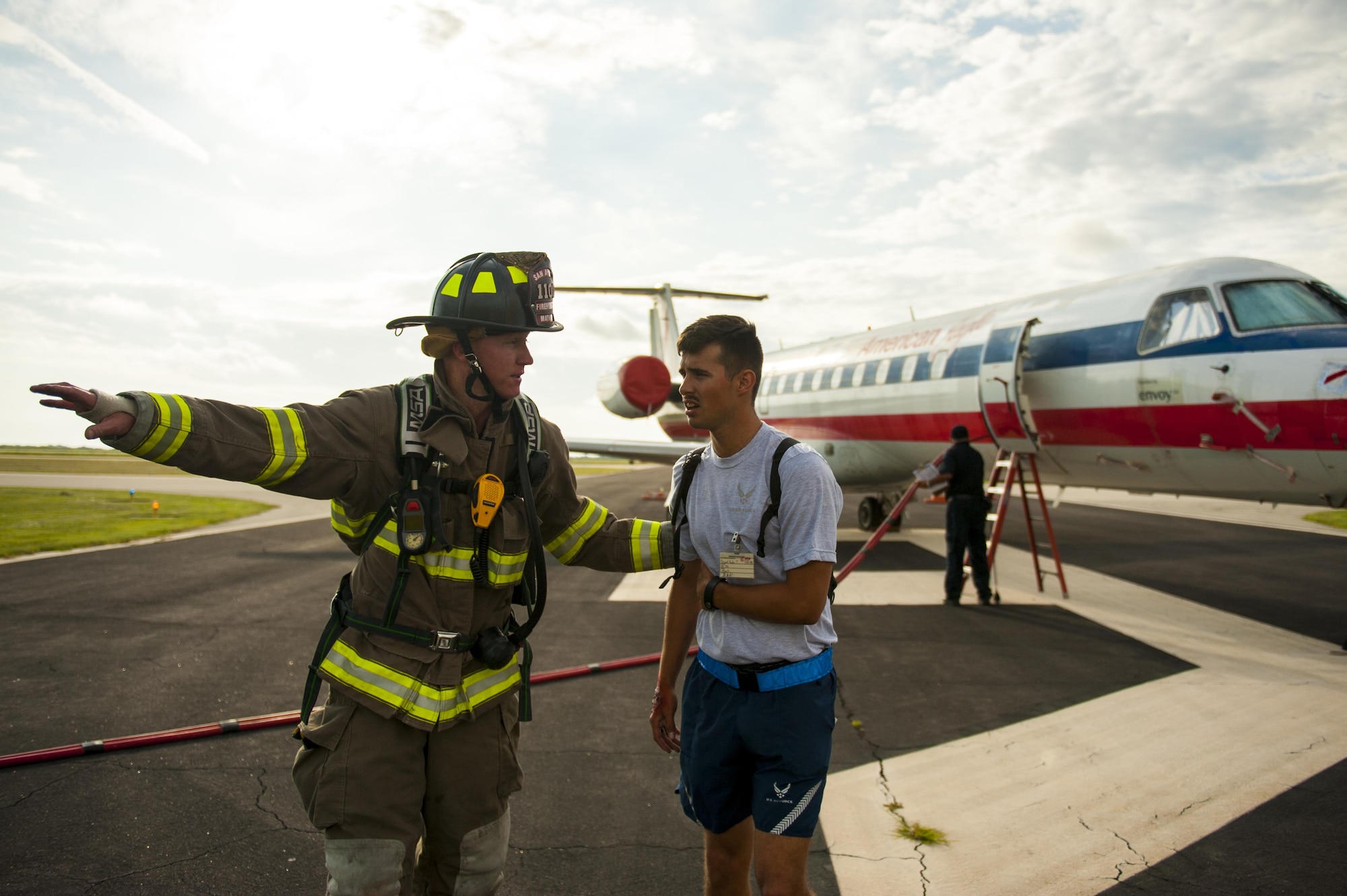 Shane Mathews, San Angelo firefighter, helps a crisis actor get to a safe location during a plane crash exercise at the Mathis Regional Airport San Angelo, Texas, July 13, 2017. Firefighters and other emergency services responded to a simulated plane crash in which a military aircraft collided with a commercial passenger aircraft. (U.S. Air Force photo by Senior Airman Scott Jackson/Released)
