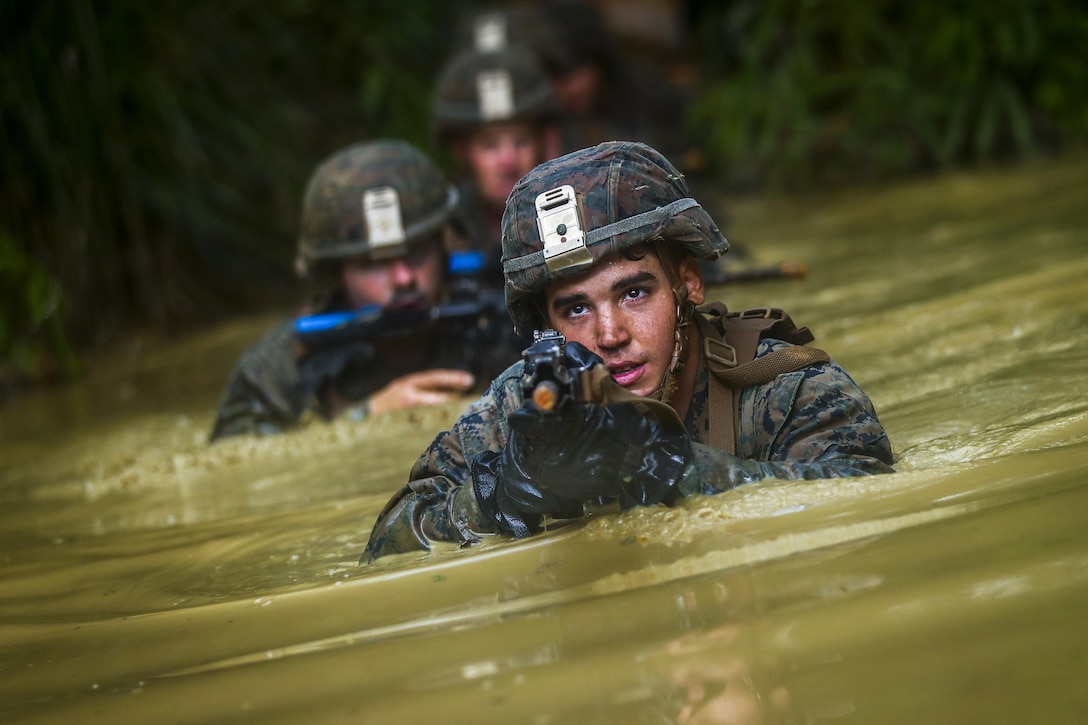 Marine Cpl. Bryan Hernandezrodriguez travels through the “pit and pond” obstacle during the endurance course at Camp Gonsalves, Okinawa, Japan, July 7, 2017. Marine Corps photo by Cpl. Aaron S. Patterson