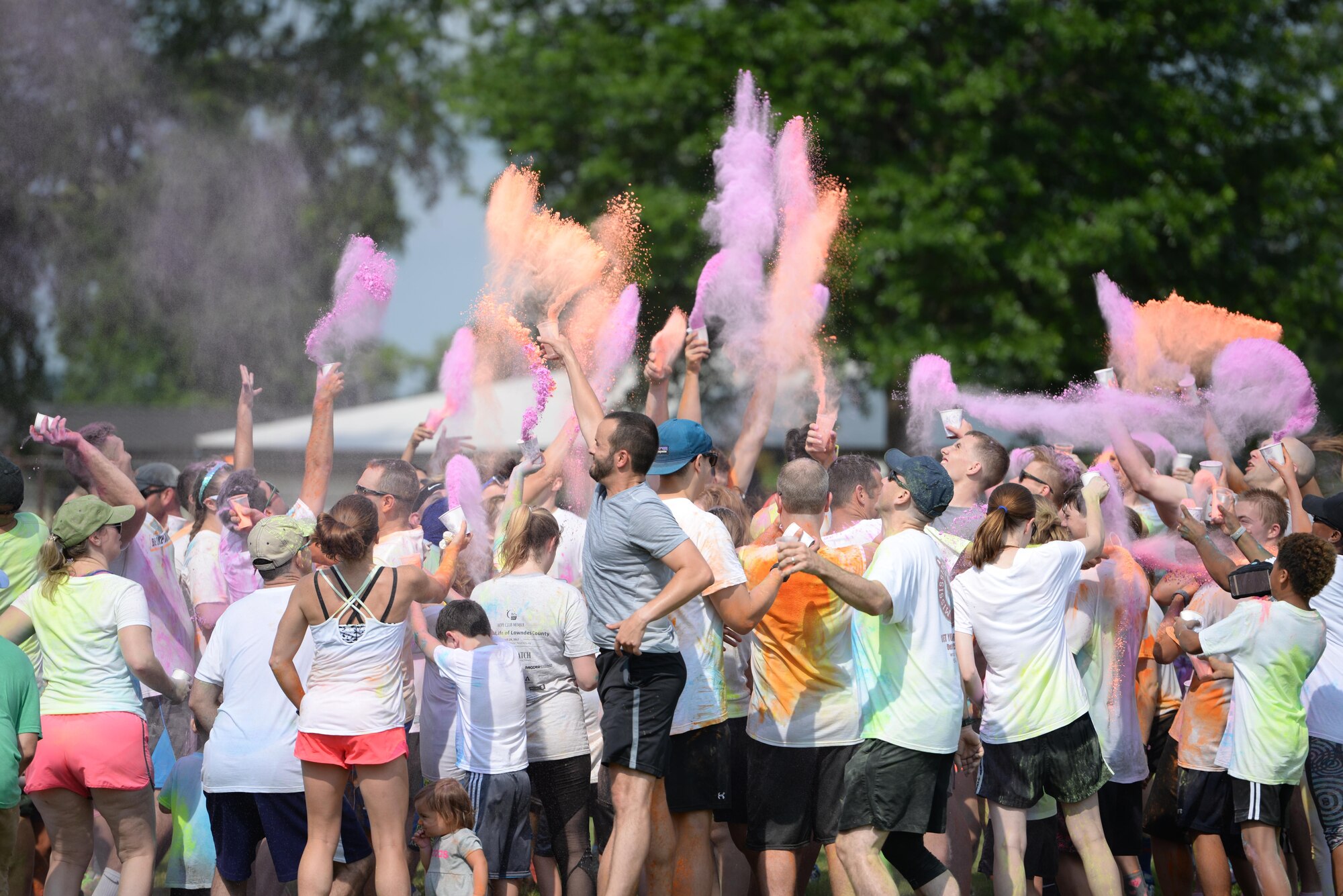 Participants throw a flurry of powder in the air after the 5th annual Color Run July 8, 2017, at Columbus Air Force Base, Mississippi. The Color Run had two routes, a 5-kilometer run and a 2-mile route. The Red Cross provided water, Gatorade and fruits after the race. (U.S. Air Force photo by Airman 1st Class Keith Holcomb)