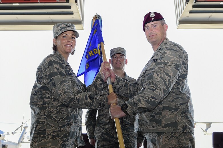 U.S. Air Force Col. Jennifer Short, 23d Wing commander, Moody Air Force Base, Ga., passes the guidon to Col. Jason Pifer, newly appointed 563rd Rescue Group commander, during a change of command ceremony at Davis-Monthan Air Force Base, Ariz., July 14, 2017. Pifer is a combat rescue officer and prior commander of the 48th Rescue Squadron at Davis-Monthan AFB. (U.S. Air Force photo by Staff Sgt. Chris Drzazgowski)