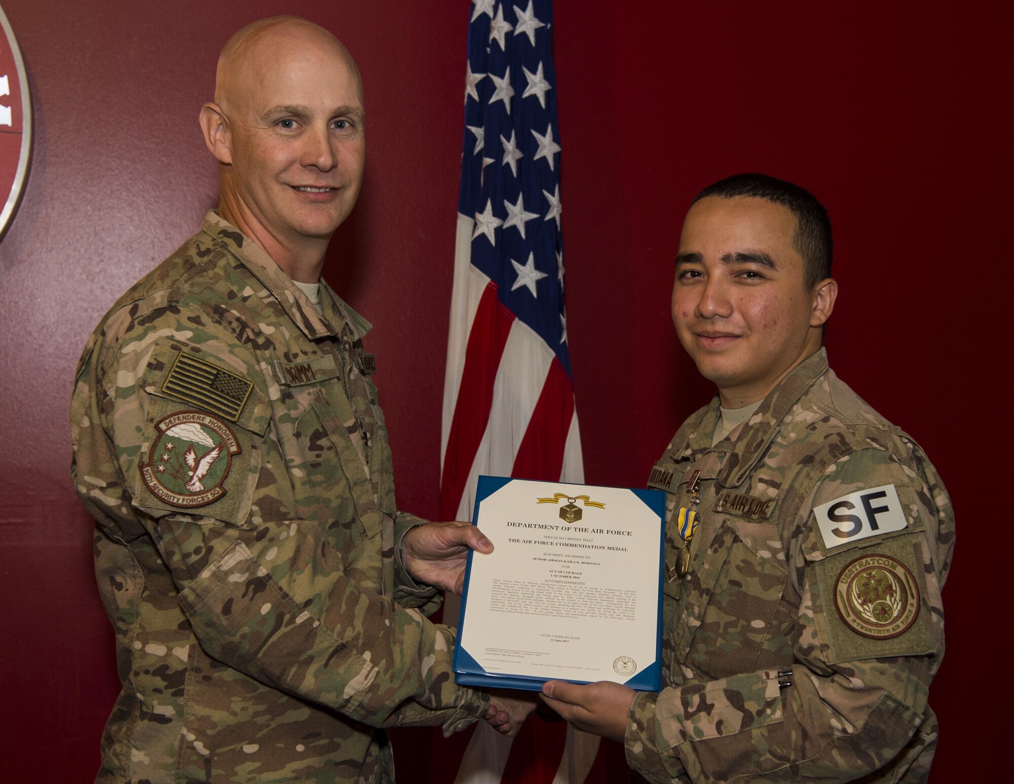 Col. John Grimm, 90th Security Forces Group commander, presents Senior Airman Kaiea Hokoana, 90th Security Forces Squadron installation patrolman, with the Air Force Commendation Medal in Cheyenne, Wyo., July 14, 2017. Hokoana received this medal for his role in providing first responder assistance which contributed to saving a motorist’s life on Oct. 1, 2016 while on leave in Maui, Hawaii. (U.S. Air Force photo by Staff Sgt. Christopher Ruano)