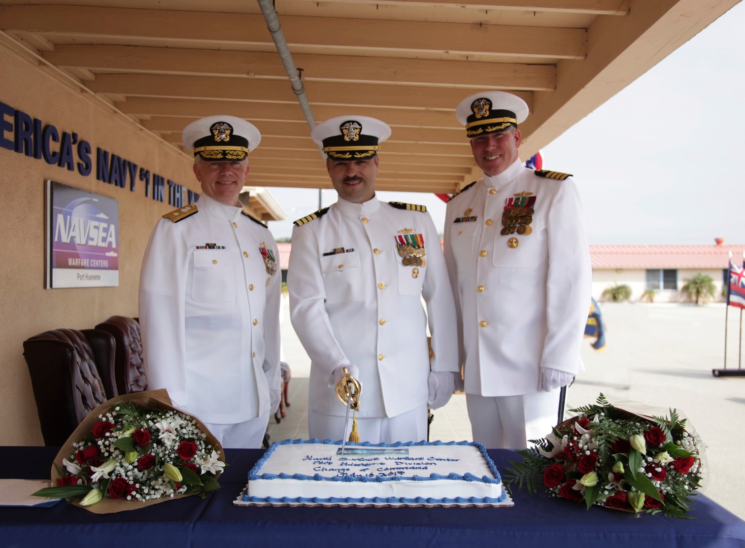 PORT HUENEME, Calif.—Naval Surface Warfare Center, Port Hueneme Division (NSWC PHD), held a change of command ceremony, July 10, where Capt. Stephen H. Murray relinquished command to Capt. Rafael “Ray” A. Acevedo. Pictured at the “ceremonial cake-cutting” with the naval officer’s sword are (from left to right): Rear Adm. John W. Ailes, deputy commander, Fleet Readiness Directorate, Space and Naval Warfare Systems Command, Capt. Rafael “Ray” A. Acevedo, current commanding officer, NSWC PHD, and Capt. Stephen H. Murray, former commanding officer, NSWC PHD and commanding officer NSWC Corona.