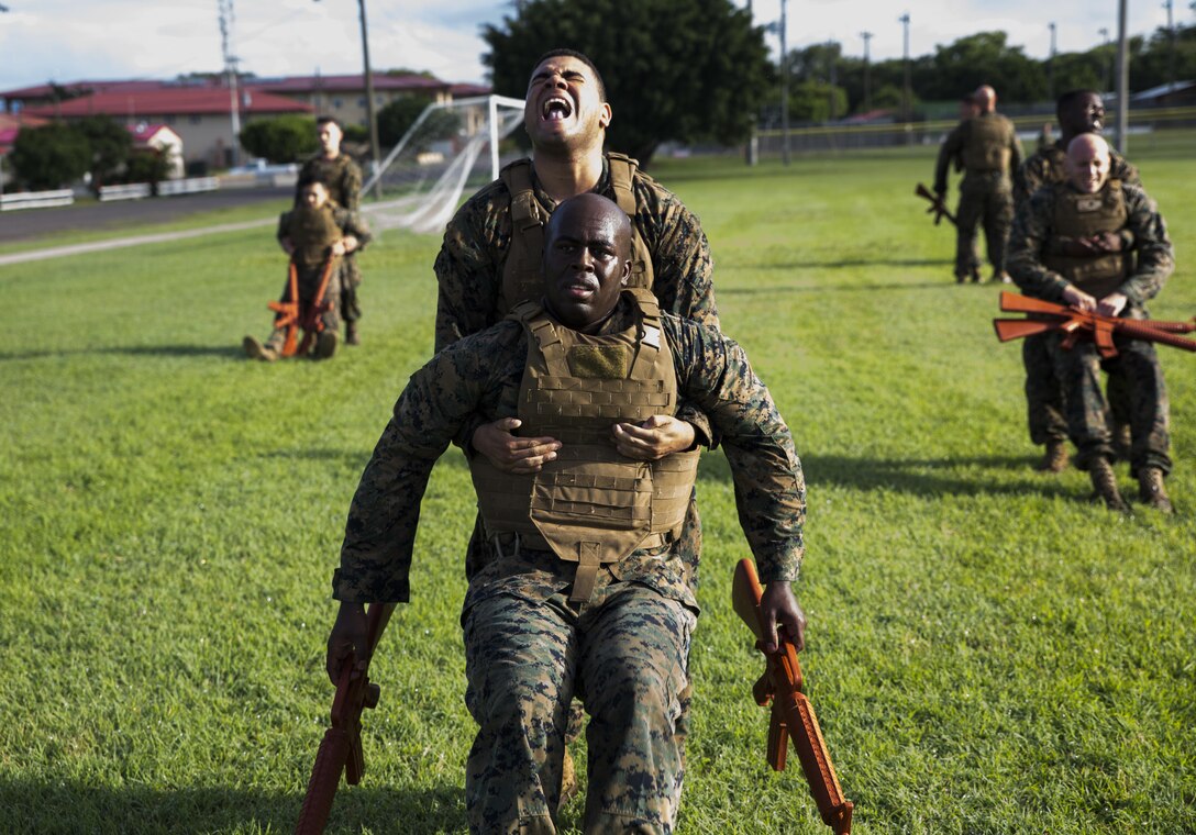U.S. Marine Cpl. Luis D. Severino, an administrative specialist with the Command Element, Special Purpose Marine Air-Ground Task Force - Southern Command, drags U.S. Marine Staff Sgt. Christopher K. Bamfo, Mobile Training Team leader, SPMAGTF-SC, while participating in a physical training session for the Marine Corps Martial Arts Program at Soto Cano Air Base, Honduras, June 26, 2017. The purpose of MCMAP is to improve physical fitness and aid in the personal development of each Marine in a team setting. The Marines and sailors of SPMAGTF-SC are deployed to Central America for the next six months to conduct security cooperation training and engineering projects with their counterparts in Honduras, Guatemala, Belize and El Salvador. (U.S. Marine Corps photo by Cpl. Melissa Martens)