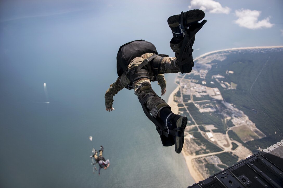 Sailors exit a CH-47 Chinook helicopter during military free-fall training in Virginia Beach, Va., July 13, 2017. The sailors are explosive ordnance disposal technicians assigned to Explosive Ordnance Disposal Group 2. Navy photo by Petty Officer 2nd Class Charles Oki