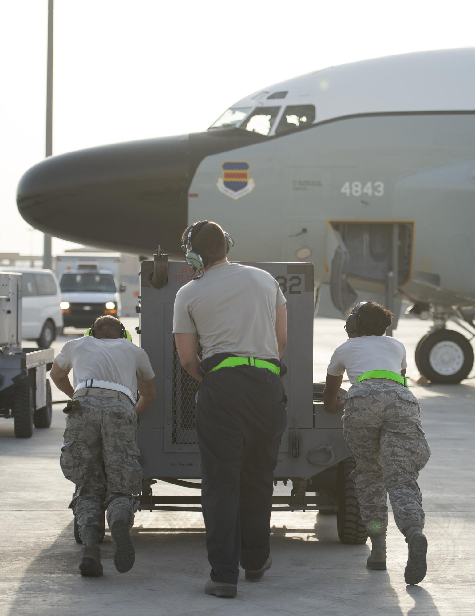 U.S Air Force Airmen with the 763rd Expeditionary Aircraft Maintenance Unit, push an external power supply to a RC-135V/W Rivet Joint at Al Udeid Air Base, Qatar, July 4, 2017.  The Airmen are responsible for keeping the RC-135V/W Rivet Joint operational so it can provide near real time on-scene intelligence collection and analysis throughout the U.S. Air Forces Central Command area of responsibility. (U.S. Air Force photo by Tech. Sgt. Amy M. Lovgren)