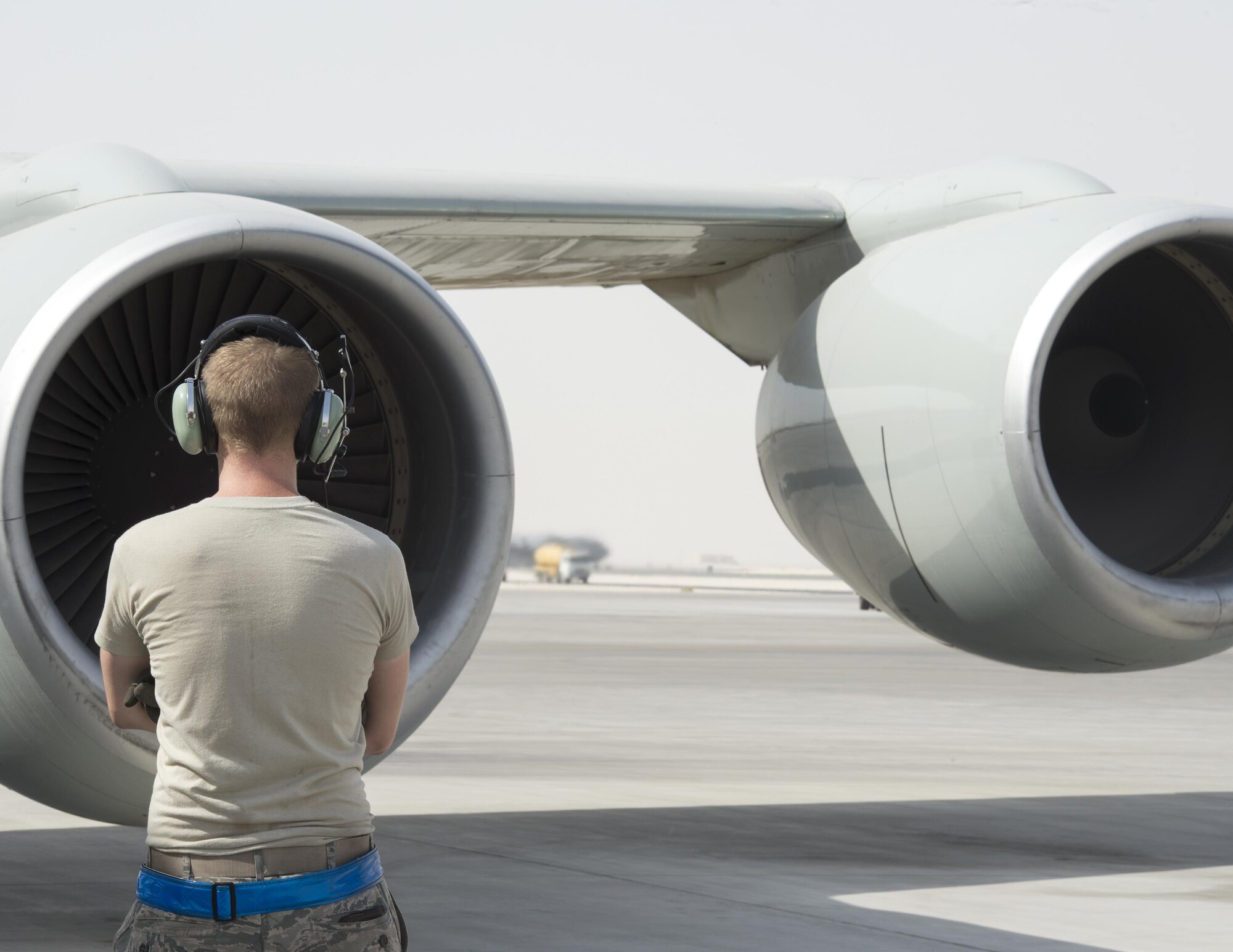 U.S Air Force Airman 1st Class Lane Fugat, a communication and navigation technician with the 763rd Expeditionary Aircraft Maintenance Unit, watches the engines start to a RC-135V/W Rivet Joint at Al Udeid Air Base, Qatar, July 4, 2017.  Fugat prepared a RC-135V/W Rivet Joint for a flight that provided near real time on-scene intelligence collection and analysis throughout the U.S. Air Forces Central Command area of responsibility. (U.S. Air Force photo by Tech. Sgt. Amy M. Lovgren)