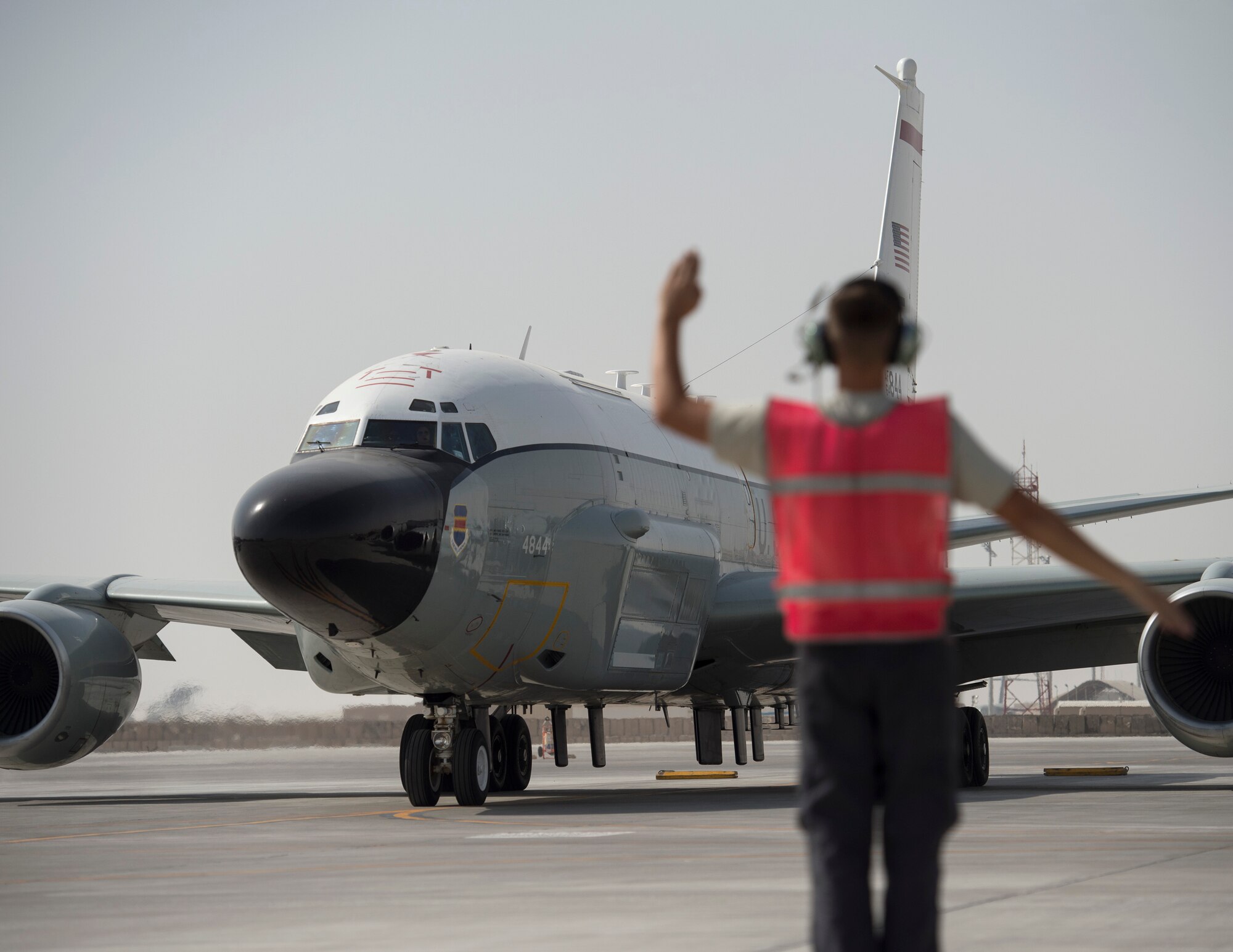 U.S Air Force Airman 1st Class David Boggs, a crew chief with the 763rd Expeditionary Aircraft Maintenance Unit, marshals a RC-135V/W Rivet Joint for take-off at Al Udeid Air Base, Qatar, July 4, 2017.  Boggs is responsible for keeping the to the RC-135V/W Rivet Joint operational so it can provide near real time on-scene intelligence collection and analysis throughout the U.S. Air Forces Central Command area of responsibility. (U.S. Air Force photo by Tech. Sgt. Amy M. Lovgren)