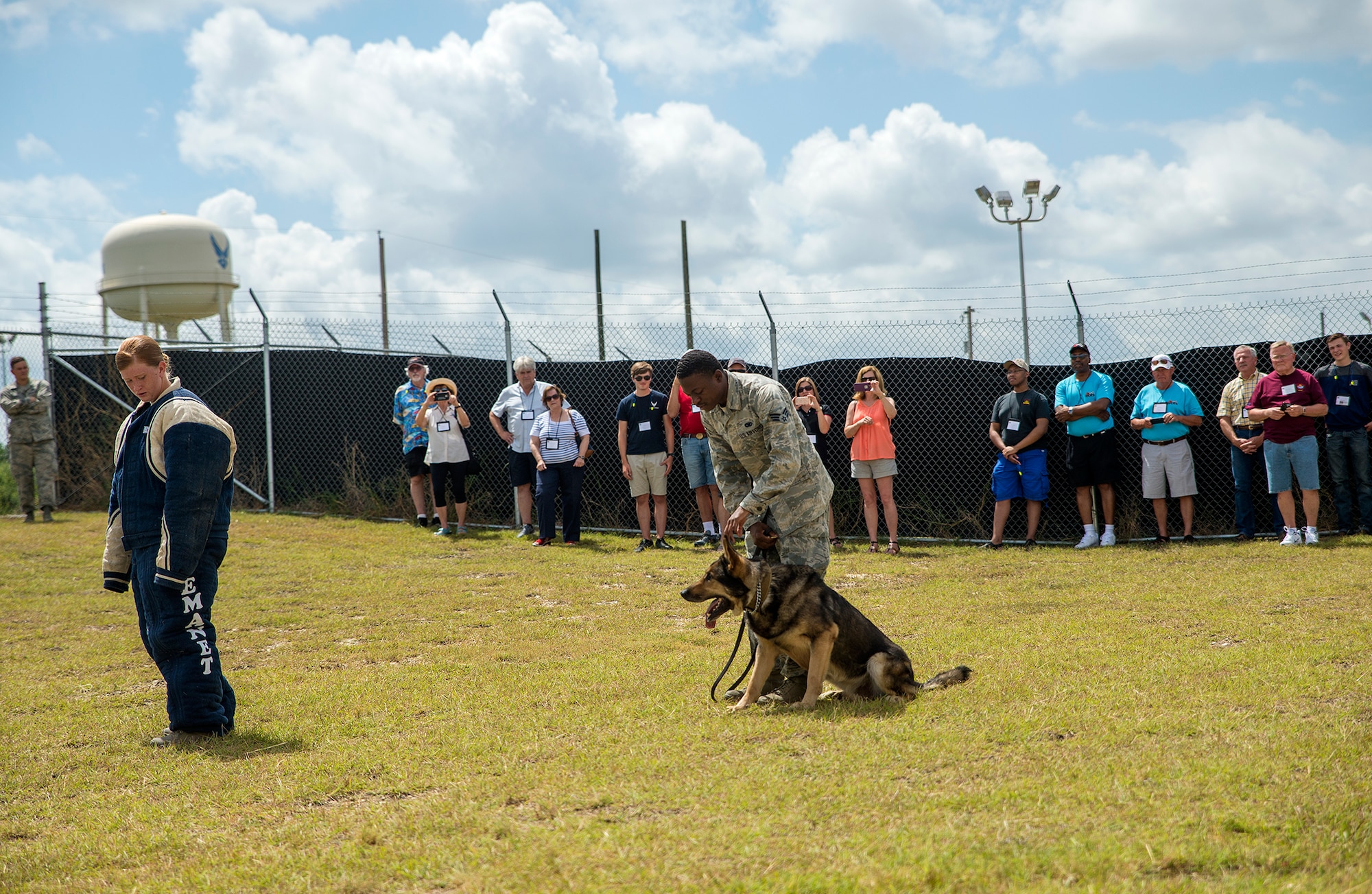 Senior Airmen Sarah Banks and Travis Waddy, 802nd Security Forces Squadron K-9 handler, perform a controlled agression demonstration for members of the National Corvette Restorers Society July 13, 2017 at Joint Base San Antonio-Lackland, Texas. The visit also included tours of a C-5M Super Galaxy aircraft and United States Air Force Airman Heritage Museum and Enlisted Character Development Center. (U.S. Air Force photo by Benjamin Faske)