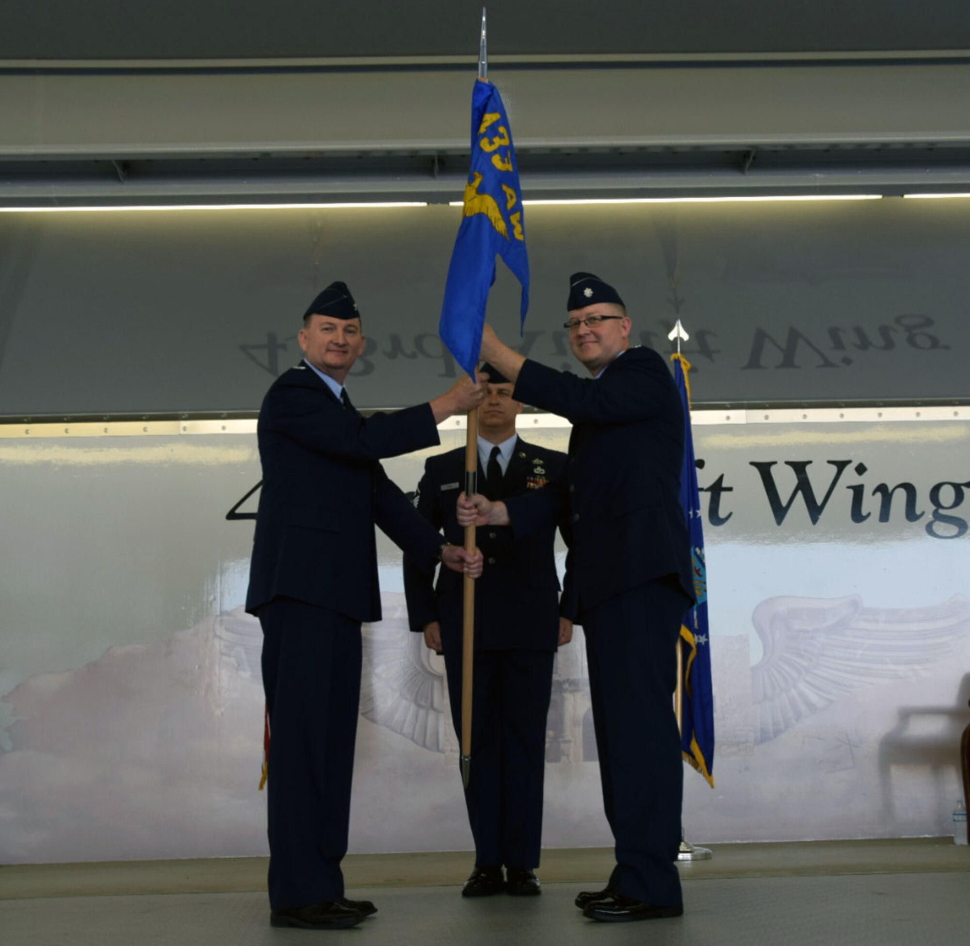 Col. Thomas K. Smith, Jr., 433rd Airlift Wing commander, passes the 433rd Maintenance Group guidon to Lt. Col. Charles V. Pratt during an assumption of command ceremony at Joint Base San Antonio-Lackland July 15, 2017. Before taking on his present role, Pratt served as the 129th Maintenance Squadron commander at Moffett Federal Air Field with the California Air National Guard. (U.S. Air Force photo/Tech Sgt. Carlos J. Trevino)
