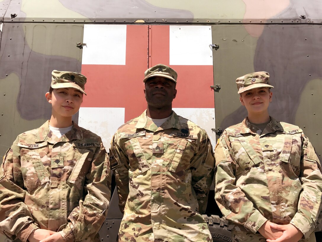 Spc. Leia Zenk, left, Sgt. Rashaun Smith, center, and Spc. Lisa Rose, right, Army Reserve Soldiers with the 7th Mission Support Command’s Medical Support Unit – Europe, pose in front of the Troop Medical Clinic July 14, 2017 at Novo Selo Training Area in Bulgaria. The three Soldiers stayed busy during Exercise Saber Guardian 17, learning new jobs and volunteering their skills at the clinic. 