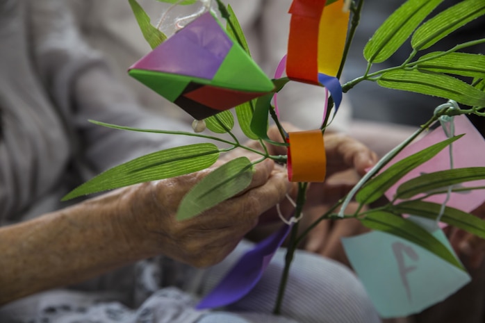 Kikuko Shinjo, a Kinjuen Nursing Home resident, helps tie a wish to a bamboo branch during a nursing home visit with the Marine Corps Air Station Iwakuni Cultural Adaptation Program at Iwakuni City, Japan, July 7, 2017. The nursing home invited tenants of MCAS Iwakuni to celebrate Tanabata, also known as the star festival. Participants in the event wrote their wish on a colorful piece of paper and tied it to a bamboo branch so the wind can carry it, let it manifest and take it to the stars. (U.S. Marine Corps photo by Lance Cpl. Gabriela Garcia-Herrera)