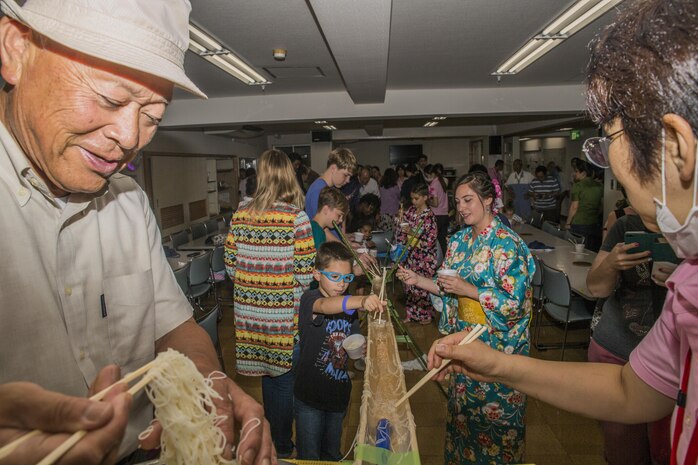 Marine Corps Air Station Iwakuni and Kinjuen Nursing Home residents eat somen nagashi, or sliding somen noodles, during a nursing home visit with the MCAS Iwakuni Cultural Adaptation Program in Iwakuni City, Japan, July 7, 2017. The nursing home invited tenants of the air station to celebrate a Tanabata, also known as the star festival. It gave tenants of the air station a taste of Japanese culture and friendship. (U.S. Marine Corps photo by Lance Cpl. Gabriela Garcia-Herrera)