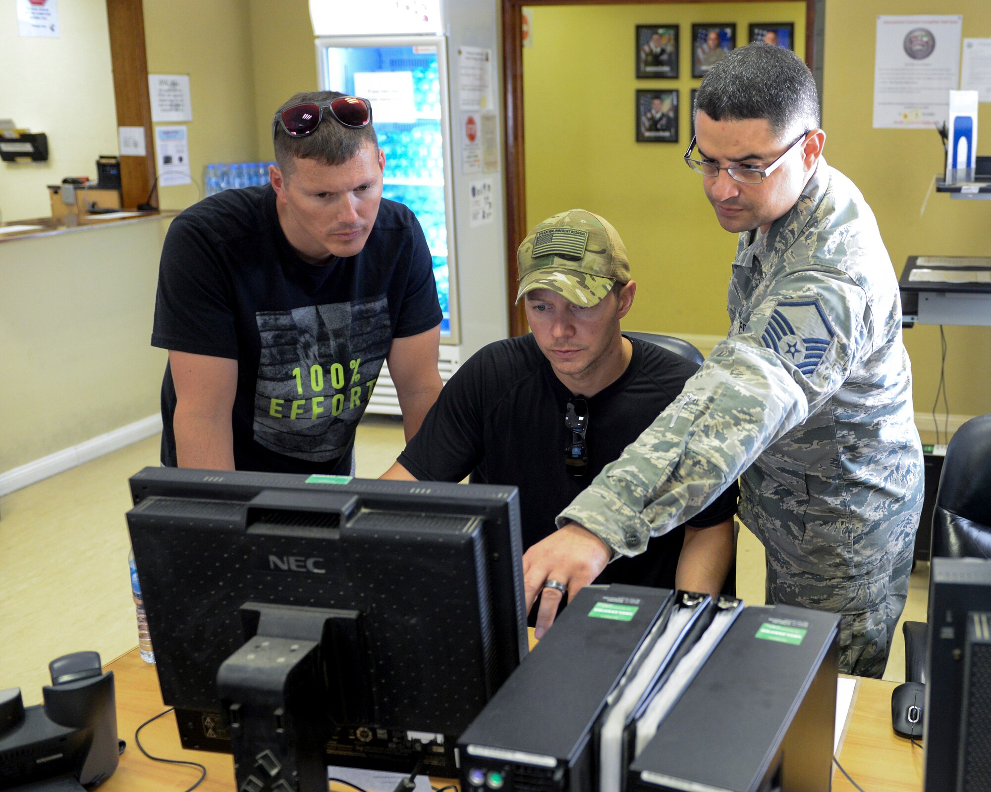 U.S. Air Force Master Sgt. Roberto Pagan, financial services flight chief assigned to the 379th Expeditionary Comptroller Squadron, Financial Services Flight, assists military members at a self-help computer located in the finance building at Al Udeid, Air Base, Qatar, June 13, 2017. The FMF assists deployed military members with travel pay, military pay and dispersal of funds. (U.S. Air National Guard photo by Tech. Sgt. Bradly A. Schneider/Released)